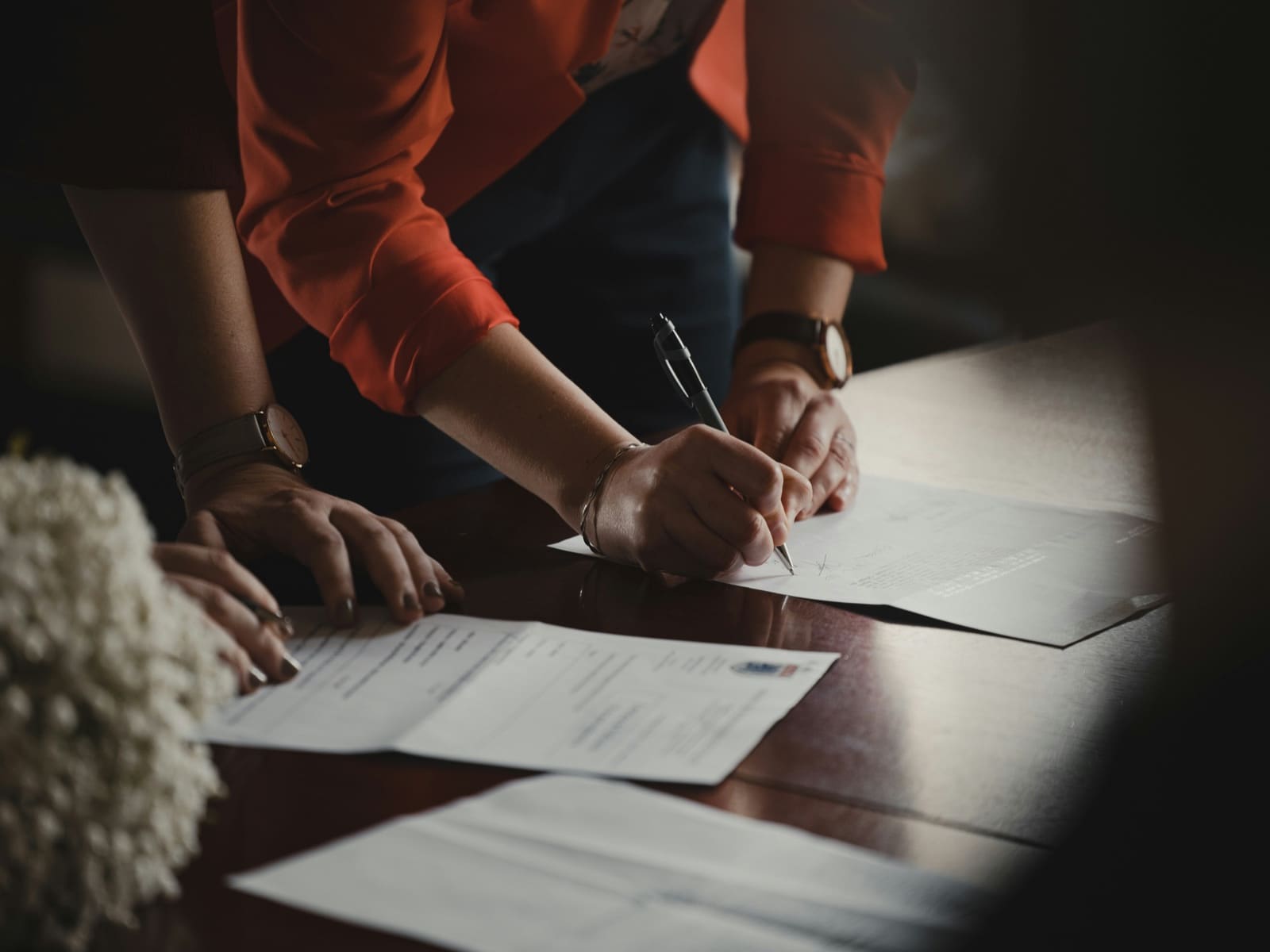 Two people signing property documents at a table