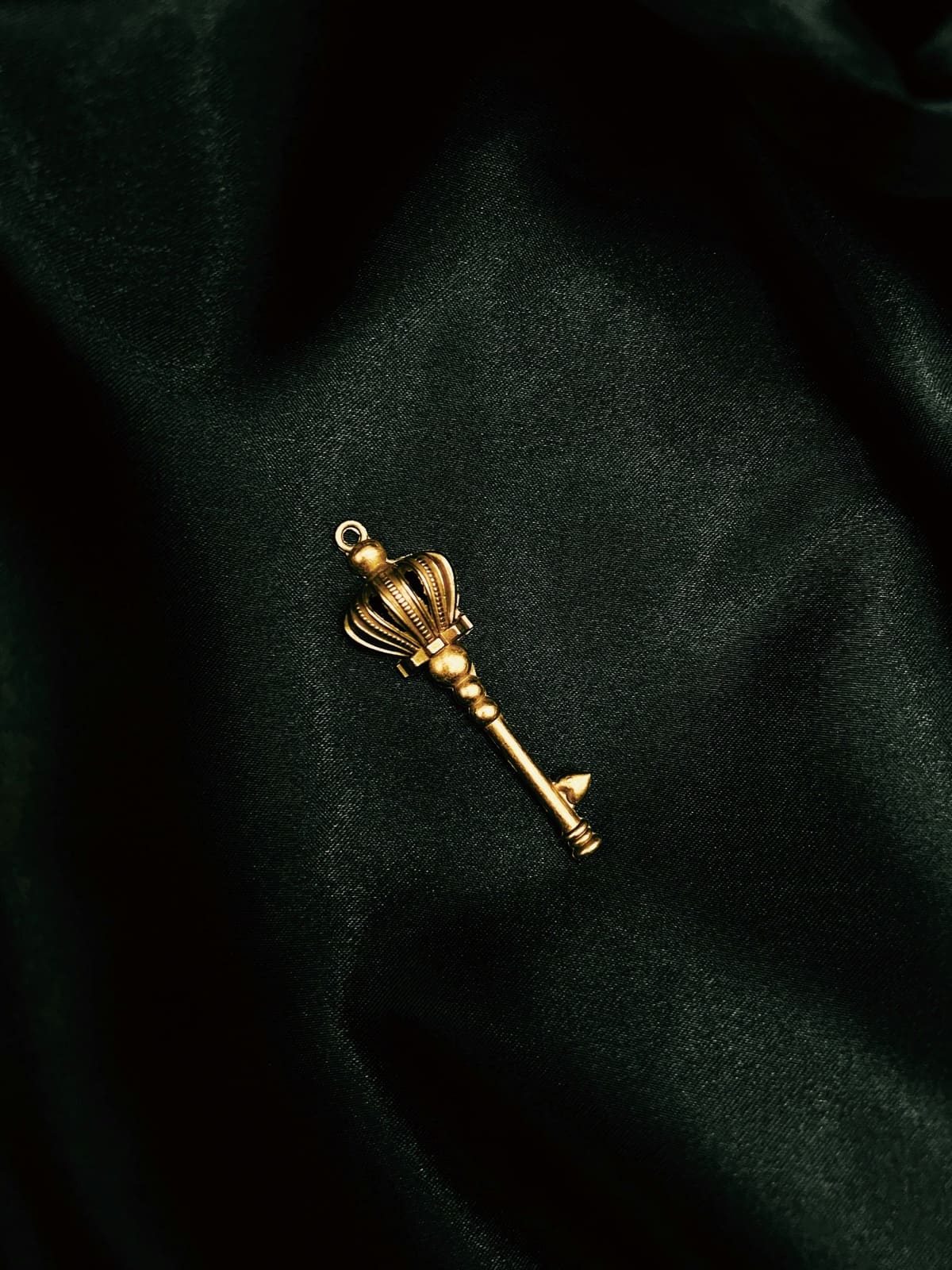 An ornate gold key resting on dark fabric