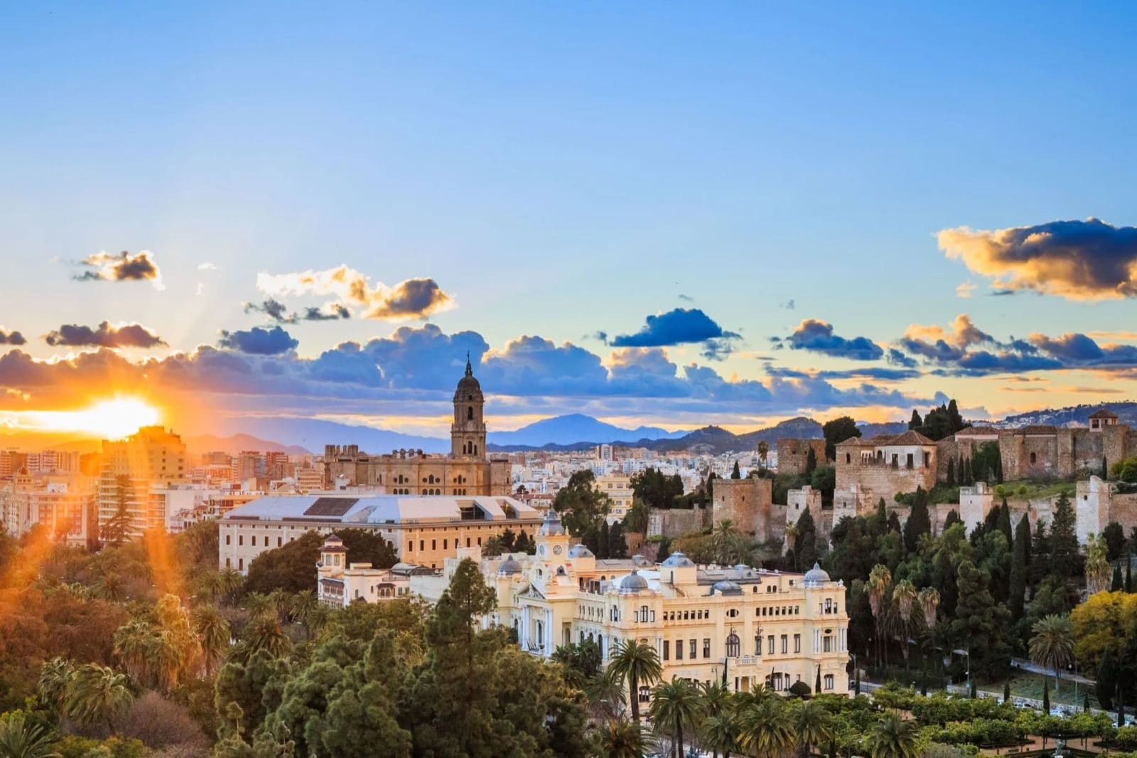 Málaga's skyline at sunset, with the cathedral tower and Alcazaba fortress above the old town