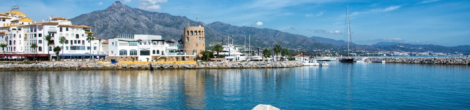 The marina at Puerto Banús with its control tower, white apartment buildings and La Concha mountain behind