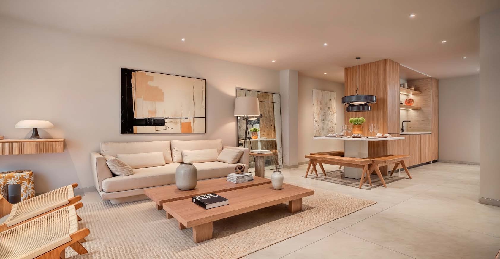 An open plan living room in one of the combined homes, with two sofas around a low wooden table and the kitchen at the back of the room. Alma Real 140, Calle Real, Estepona.