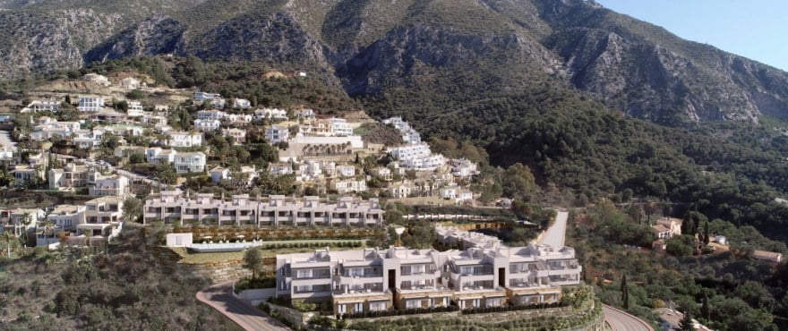 An aerial view of the Almazara estate on its hillside, with the mountain rising behind. Almazara Views, Cerros del Lago, Istán.