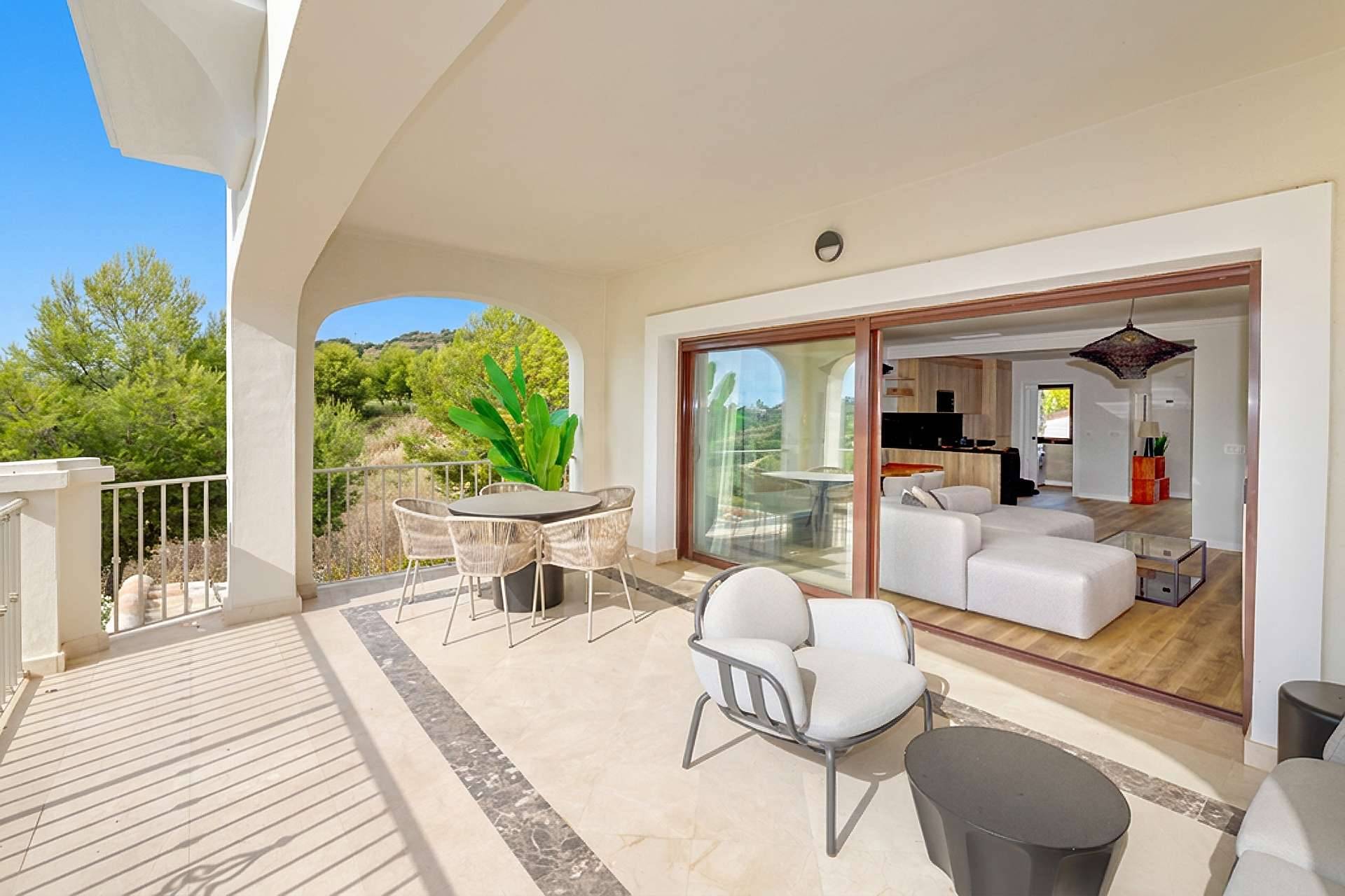 A covered terrace with a marble floor, opening through sliding glass doors onto the living room and the kitchen. Altoasis, Azata Golf, Estepona.