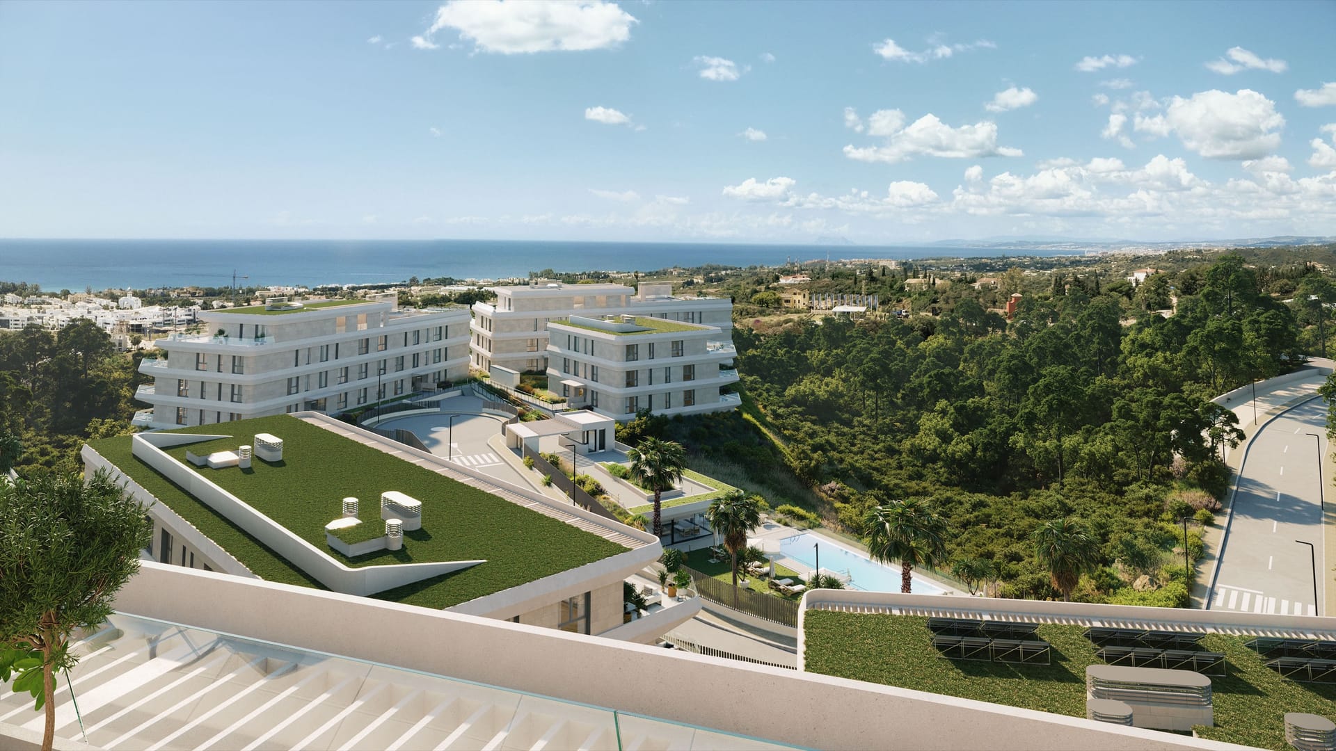 The view from an upper terrace over a planted roof to the pool, the other buildings and the sea. Australy Aures, La Resina, Estepona.