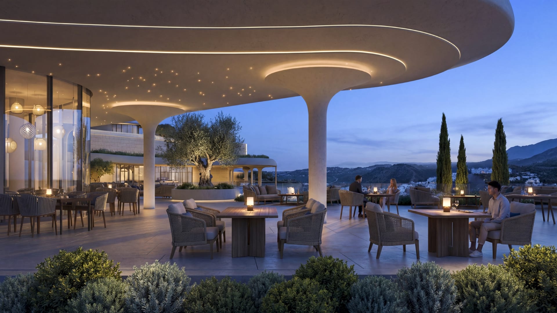 The covered restaurant terrace at dusk, with tables set out under a curved roof. Azurean Marbella, La Reserva de Alcuzcuz, Benahavís.