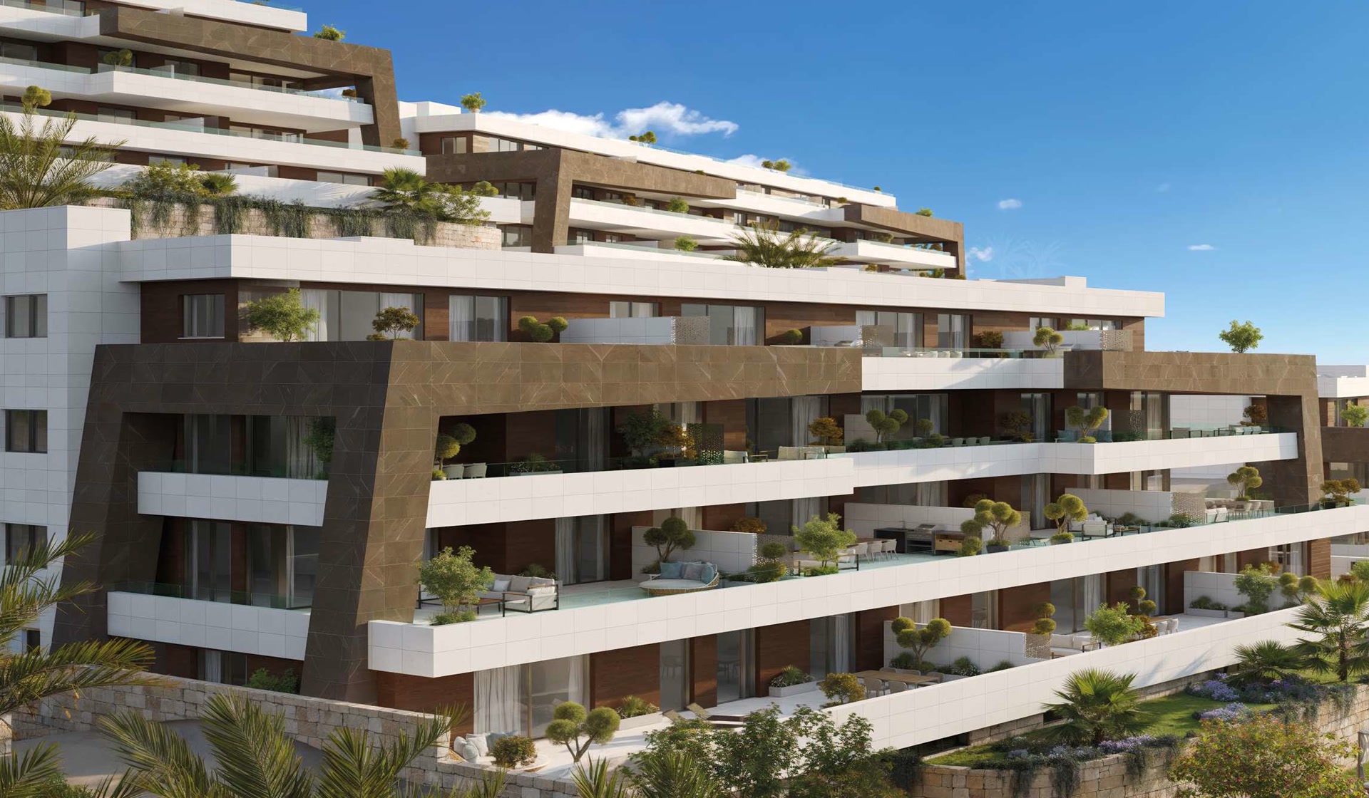 A closer view of the buildings, with deep terraces on each floor, plants along their edges and gardens behind stone walls at the foot. Balcón del Mediterráneo, New Golden Mile, Estepona.