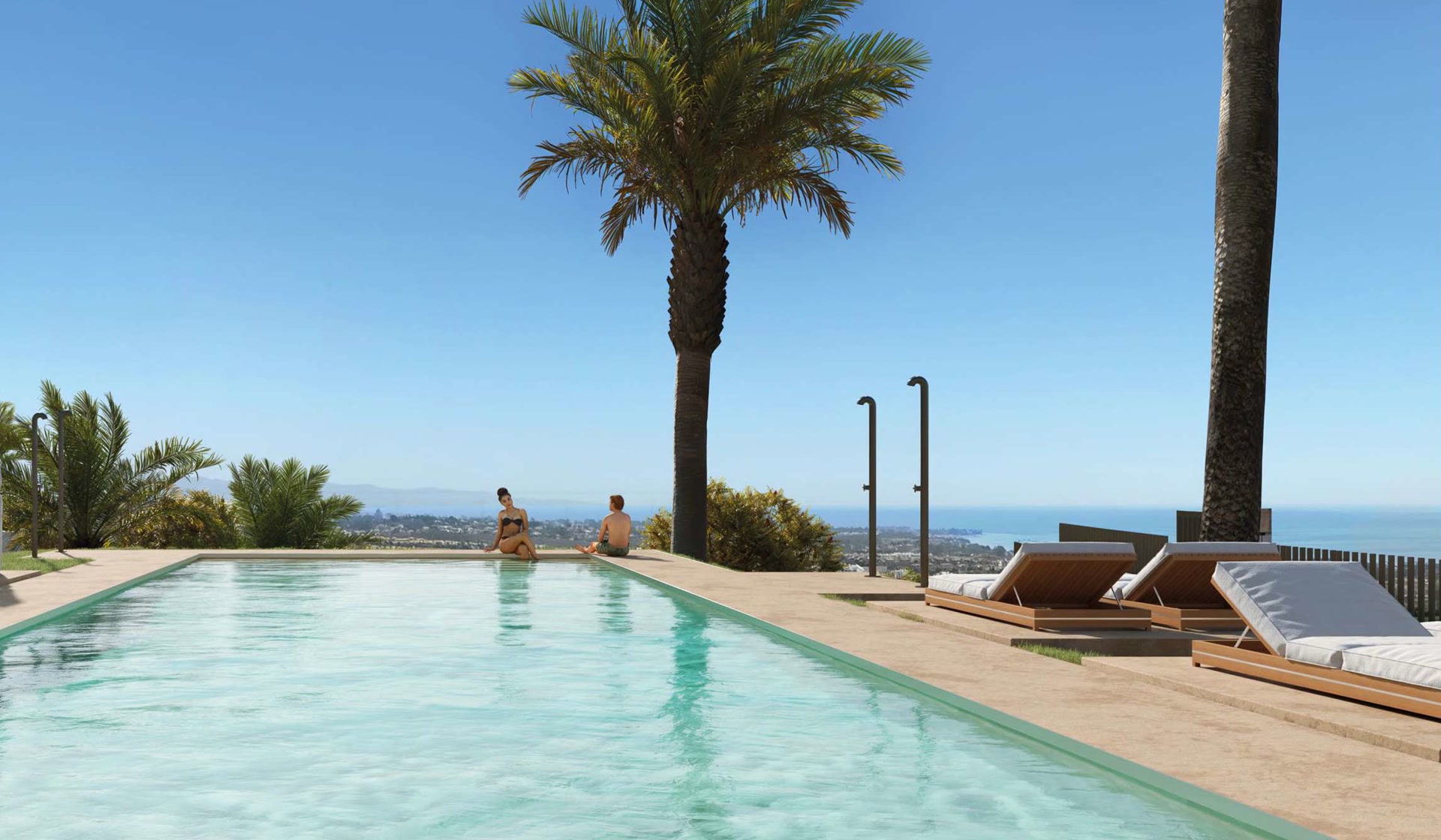 The outdoor pool, with sun loungers along its right-hand side, palm trees, and the coast and the sea in the distance. Balcón del Mediterráneo, New Golden Mile, Estepona.