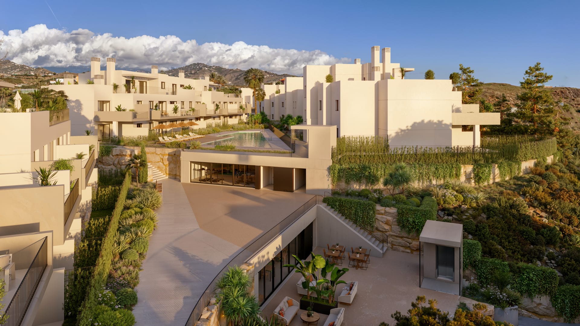 The communal area between the buildings, with the pool on a raised terrace and glazed rooms opening onto a seating area below. Baviera Golf, Baviera Golf, Caleta de Vélez.