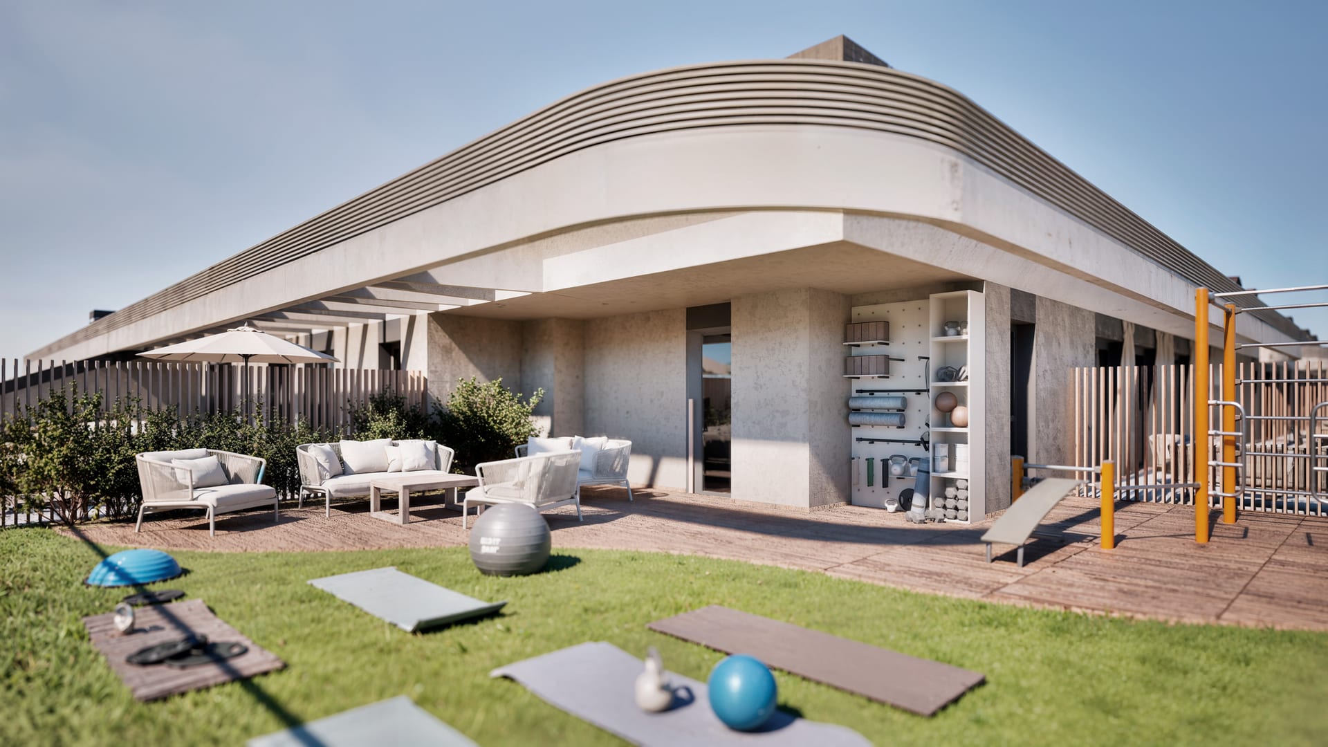 The exercise lawn, with mats laid out on the grass, a calisthenics frame on the deck and outdoor seating along the fence. Bulevar 360, Cortijo Merino, Málaga.