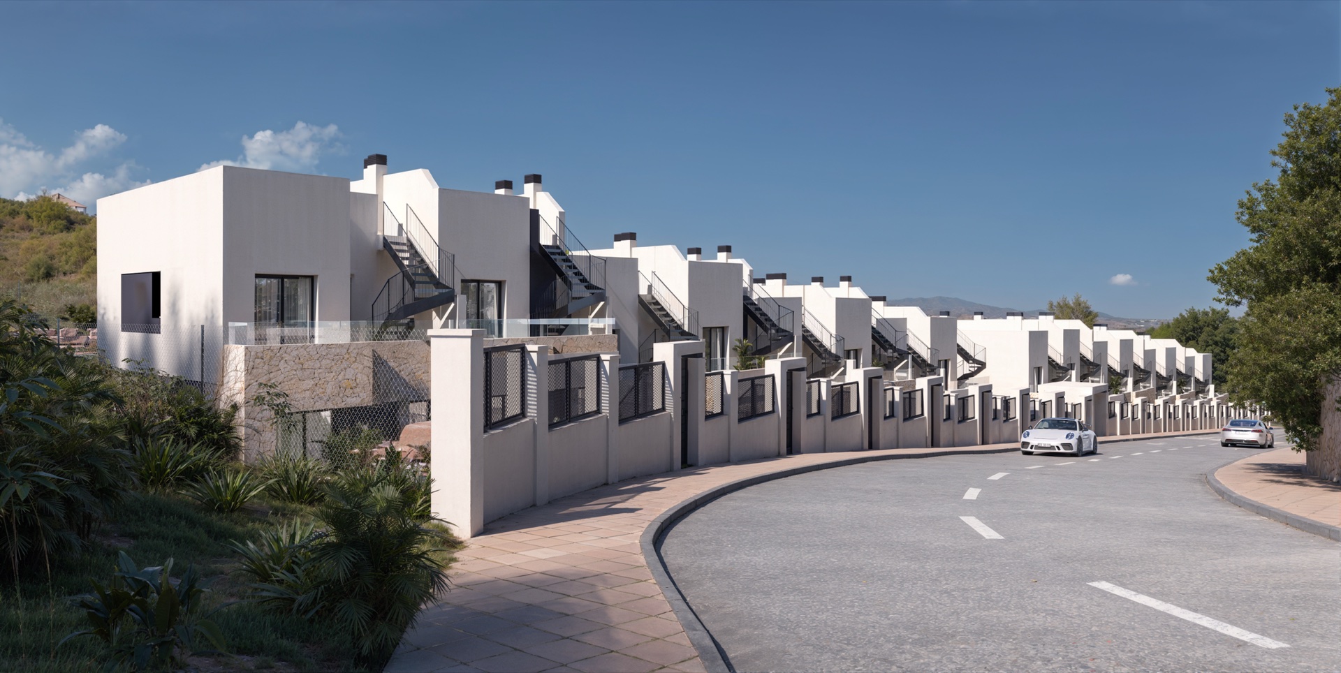 The terrace of houses seen along the street, with the external stairs up to each solarium. Cala Golf, Entrerríos, Mijas.