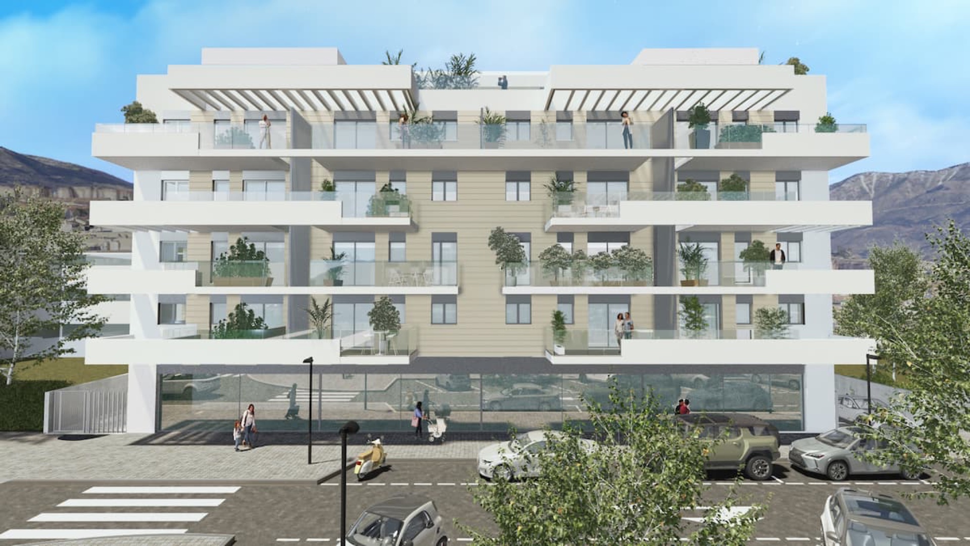 The building square on from the far side of the street, with the four shops glazed along the ground floor and the ramp down to the garage at the left-hand end. Electus, Las Lagunas, Mijas.