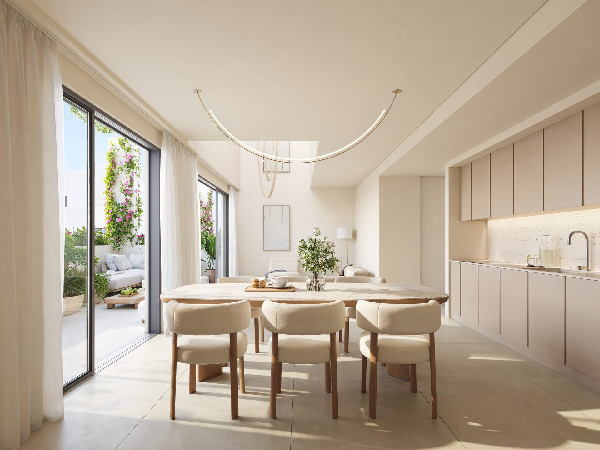 The kitchen and dining room, with pale units along one wall and glass doors onto the terrace. ERA Residence, New Golden Mile, Estepona.