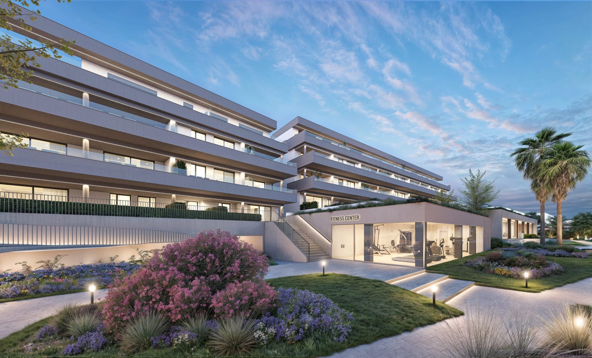 The gym in its glass-fronted room beside the gardens, lit at dusk. Etherna Homes, Valle Romano, Estepona.