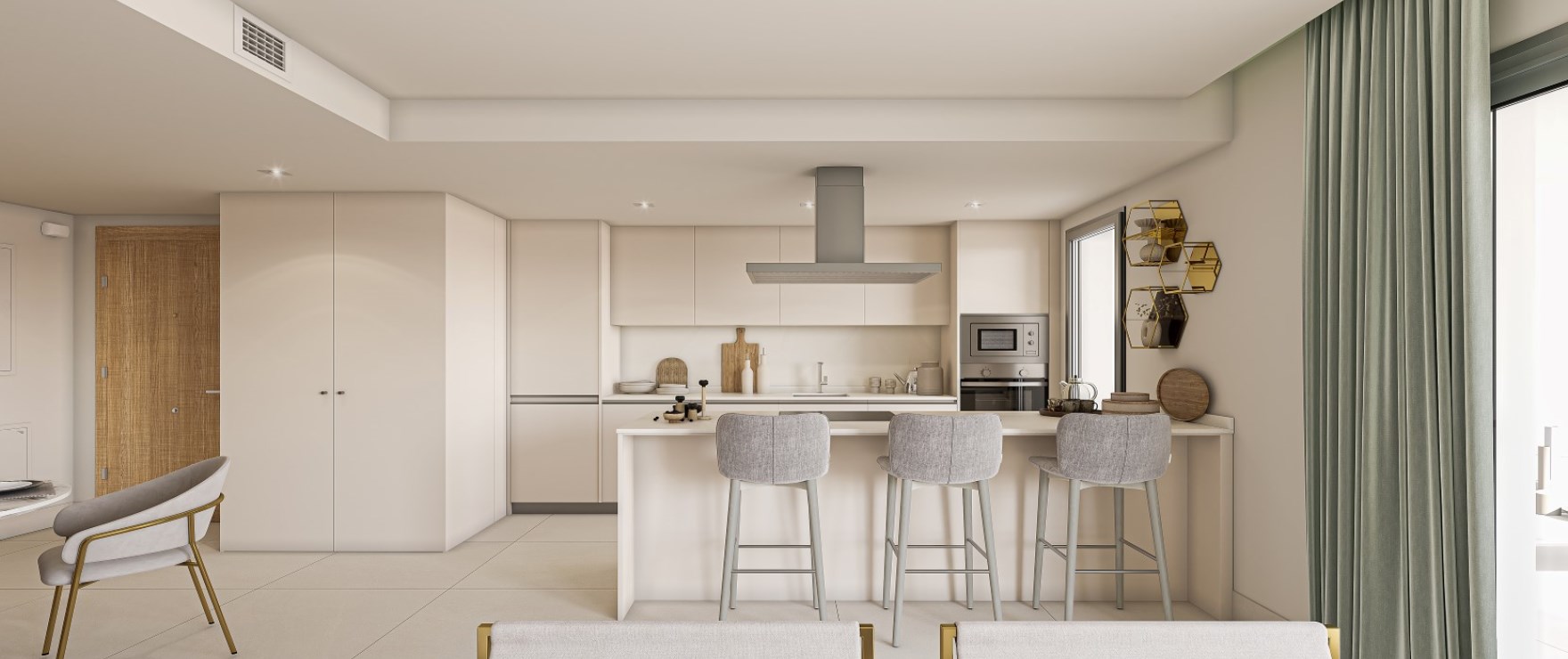 The kitchen in cream, with three stools at the island and a stainless steel extractor above the hob. Grand Bay, Bahía de las Rocas, Manilva.
