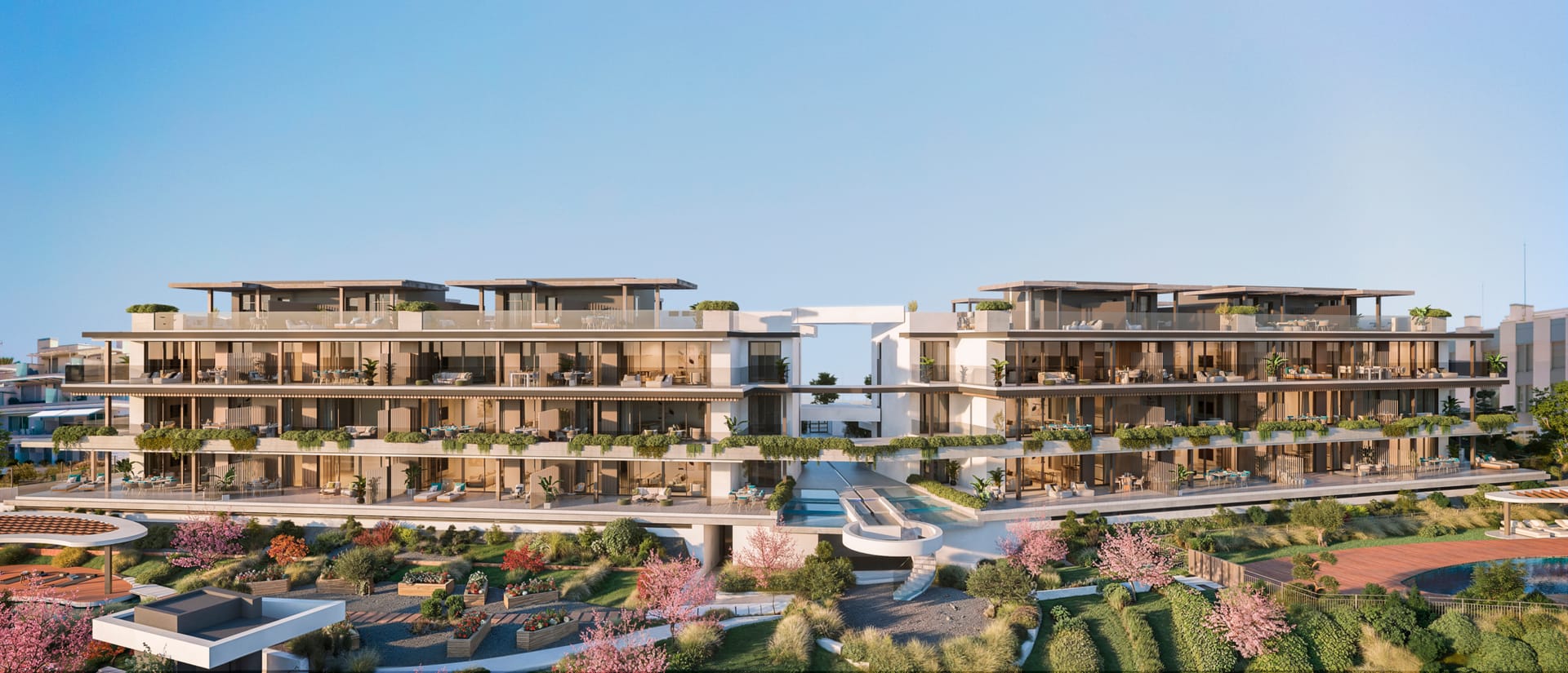 The apartment buildings above the gardens, with plants trailing over the edges of the terraces. Haiku, Cancelada, Estepona.