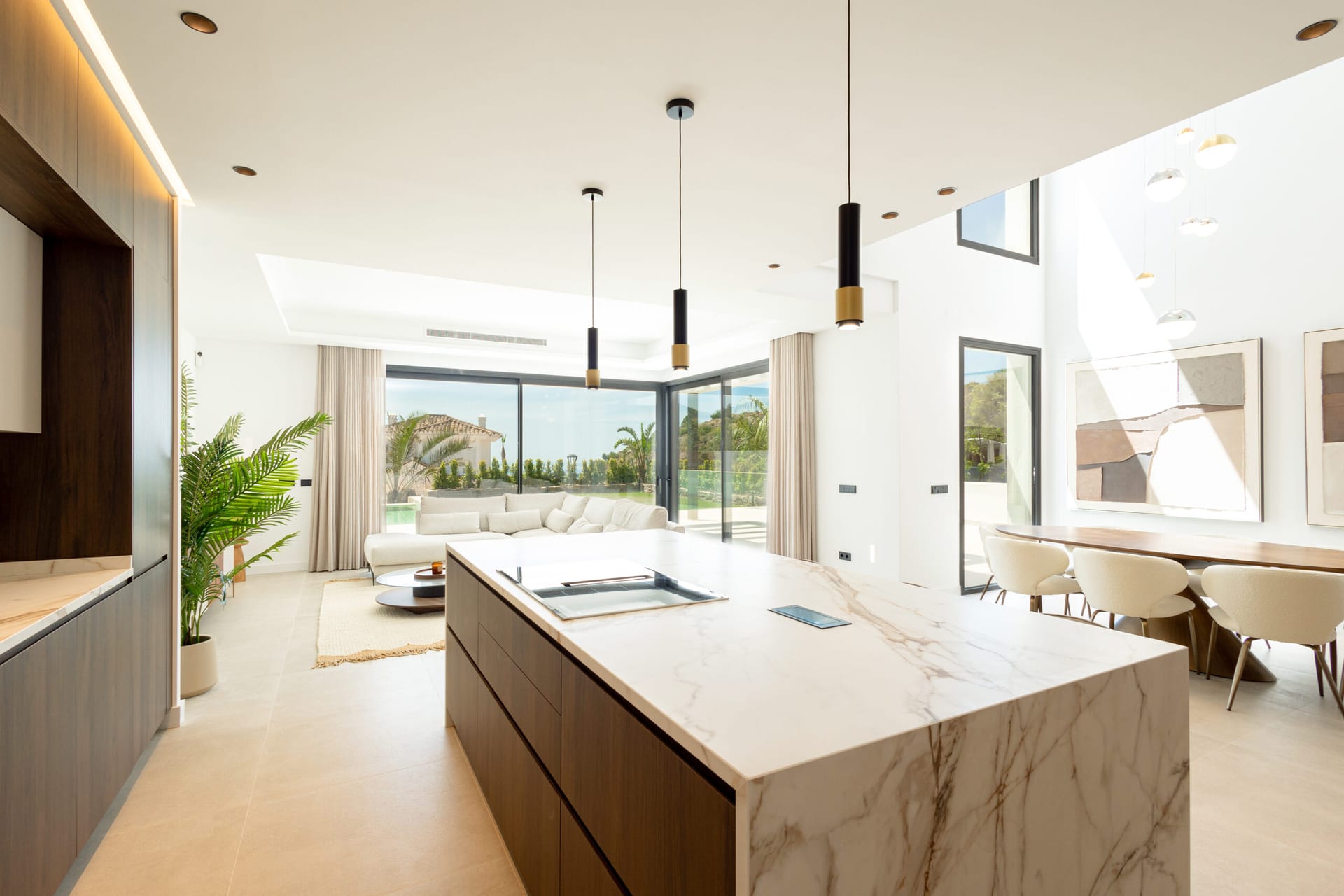 The kitchen island in the finished villa, with the living room and the garden beyond. Higuerón Hills Collection, Buenavista, Mijas.