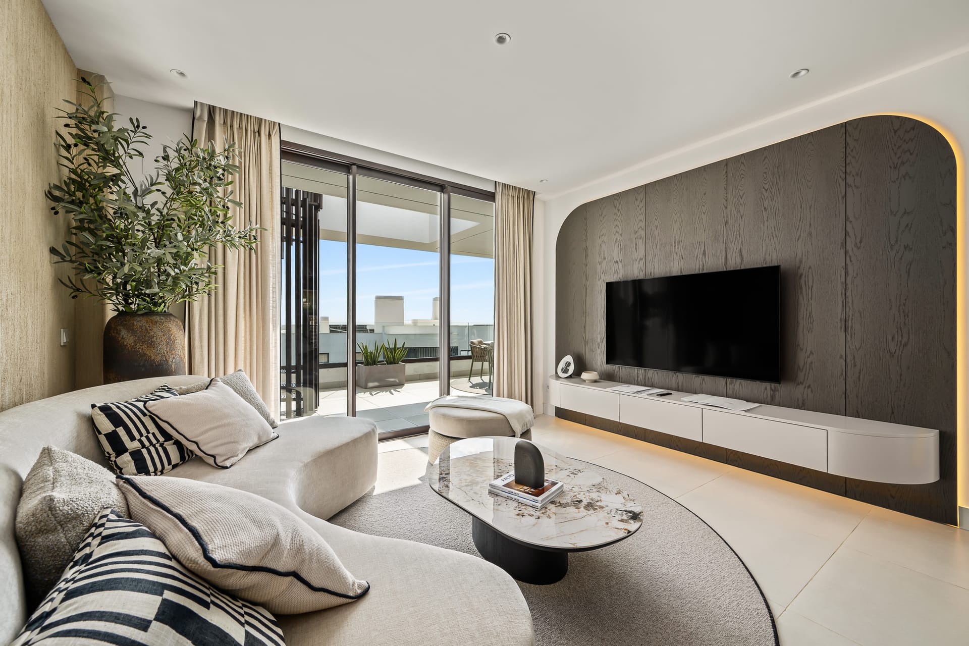 The living room of the show penthouse, with glass doors across one wall to the terrace. Horizon 36, El Higuerón, Fuengirola.