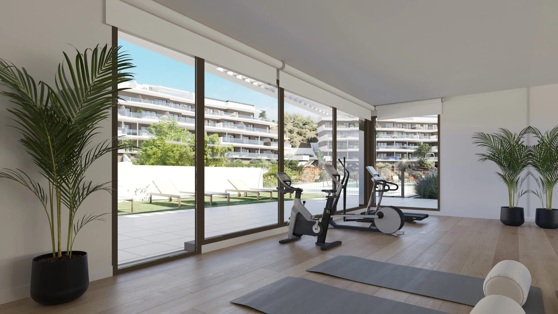 The gym, with glass doors onto a lawn and the buildings beyond. Idilia Aire, Torre de Benagalbón, Rincón de la Victoria.