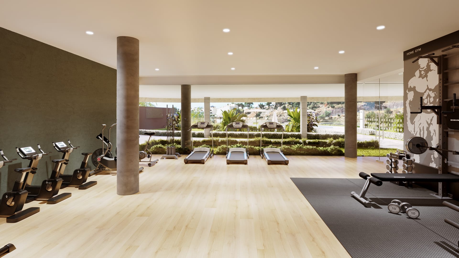 The gym, with bikes and weights on a pale wooden floor beside the windows. Korall Residences, El Higuerón, Fuengirola.