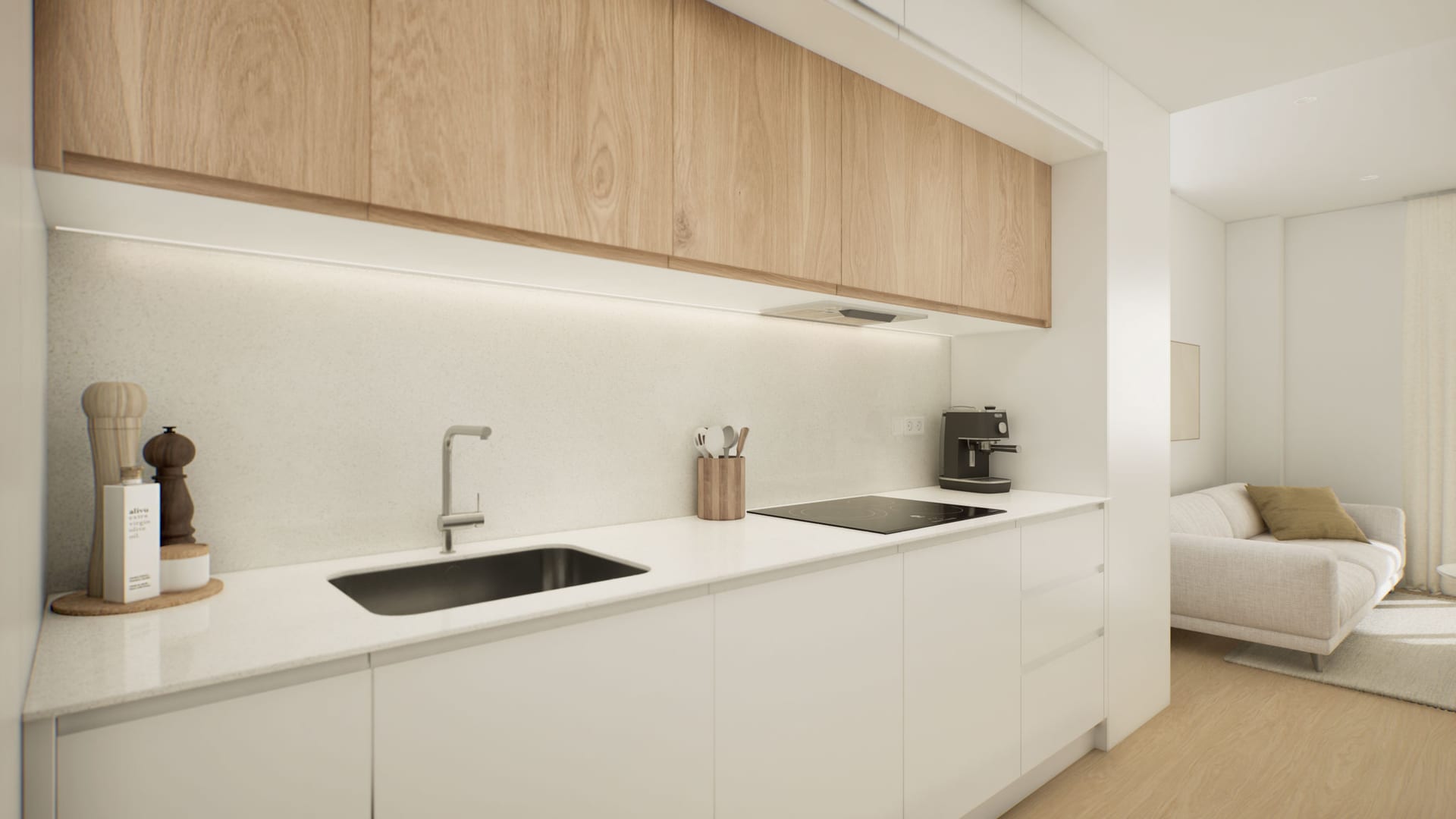 The kitchen, in white below and wood grain above, with an induction hob and a steel sink set into a white worktop. Laguna Suites, Las Lagunas de Mijas, Mijas.