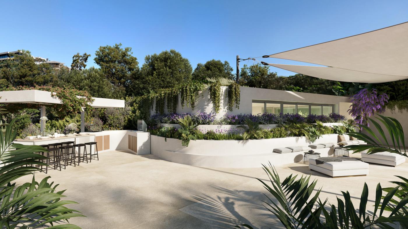 The outdoor kitchen and dining table under a shade sail, beside the gardens. Macan Beach Residences, Torrequebrada, Benalmádena.