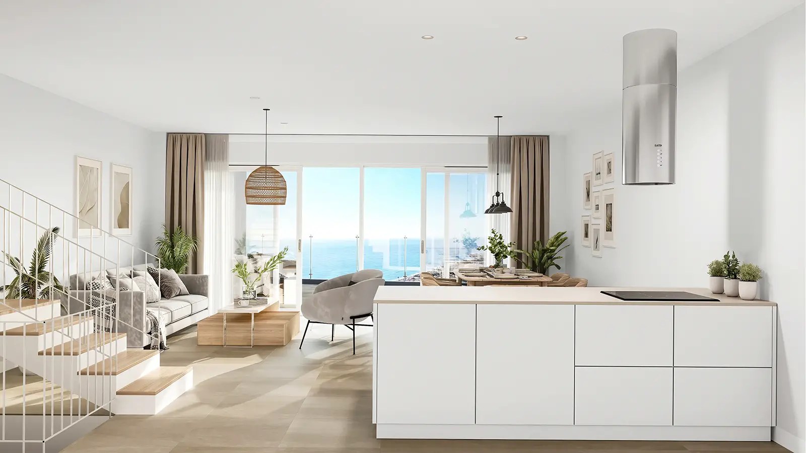 An open plan kitchen with white units and an island, a staircase on the left, and the living room and a sea view beyond. Mary’s Hill, El Peñoncillo, Torrox.