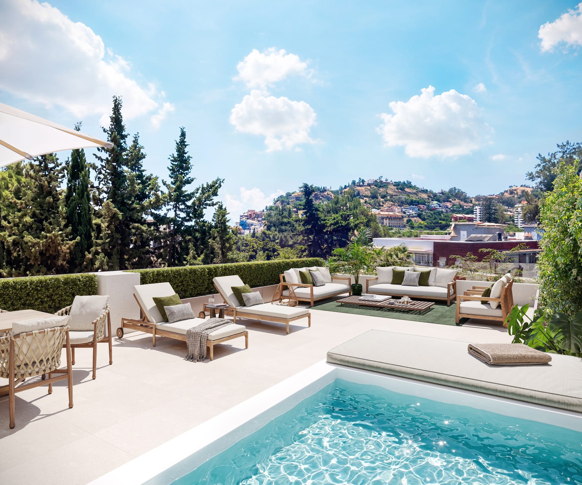 A roof terrace with a small pool in the foreground, loungers and sofas, and pine trees with the city and the hills beyond. Miramar 34, El Limonar, Málaga.