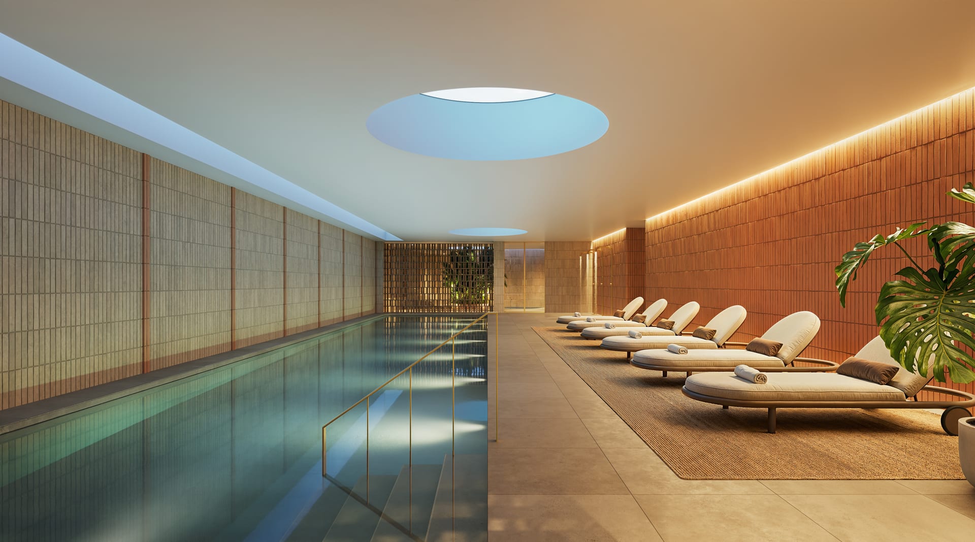 The indoor pool, a long lane of water under a round rooflight, with loungers along one side. Naven, Los Pacos, Fuengirola.
