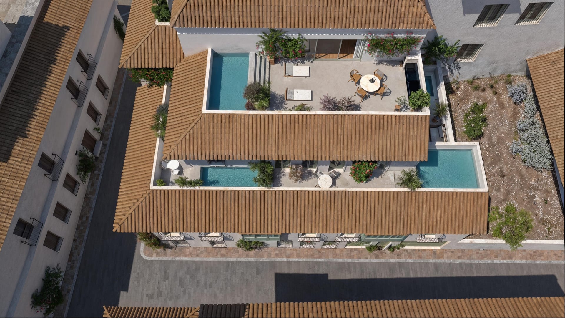 An aerial view of the building, with pools on its terraces and patio and the old town around it. Paraíso de Azahar, Old town, Estepona.