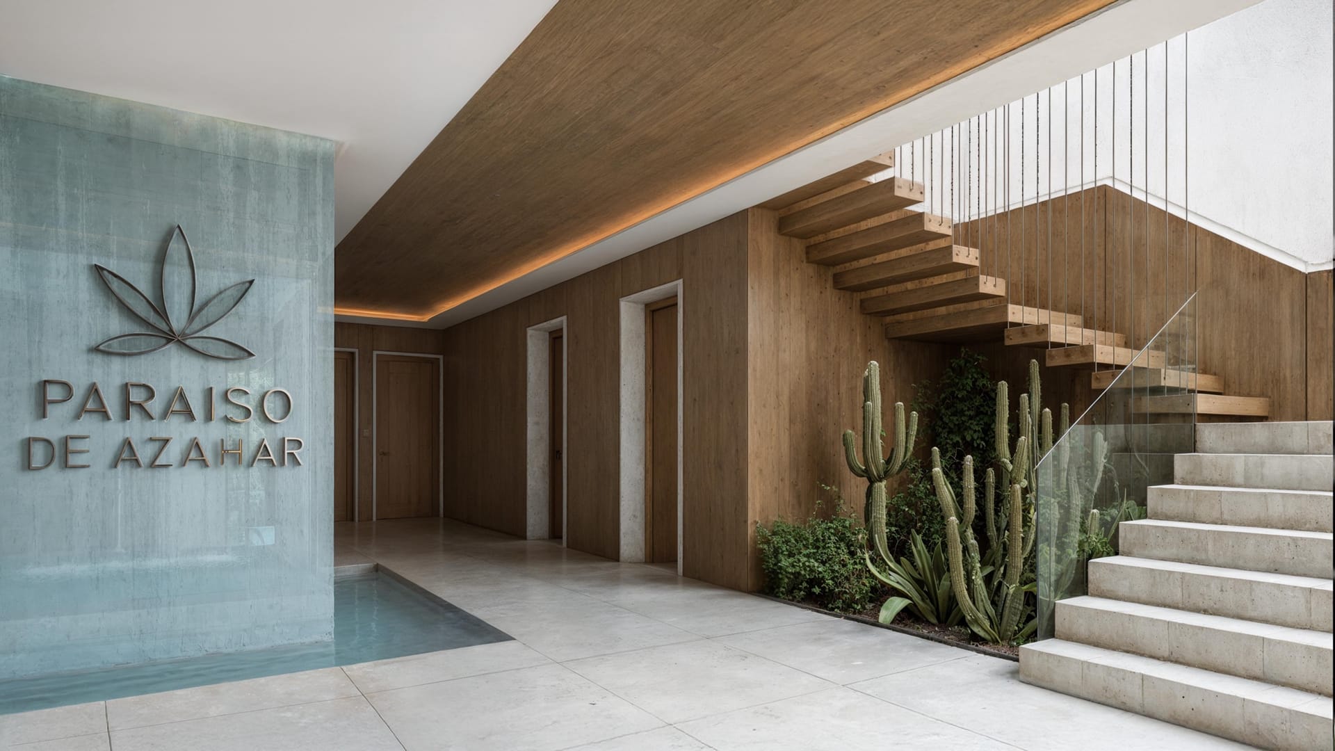 The entrance hall, with the name of the building on a stone wall and a stair rising beside cactus planting. Paraíso de Azahar, Old town, Estepona.