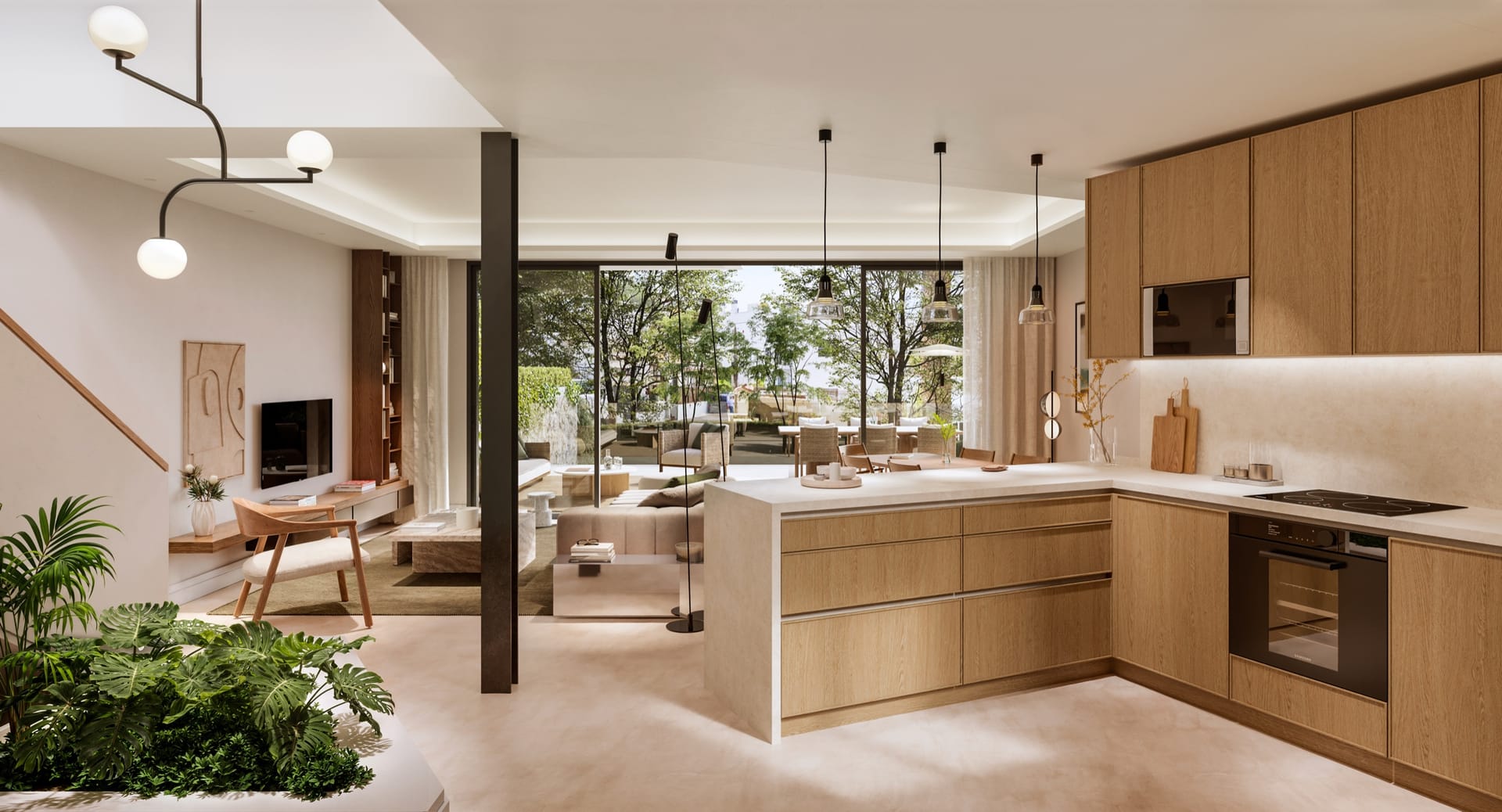 A kitchen with wood units and an island, open to the living room and the garden beyond. Portugal 2, Pedregalejo, Málaga.