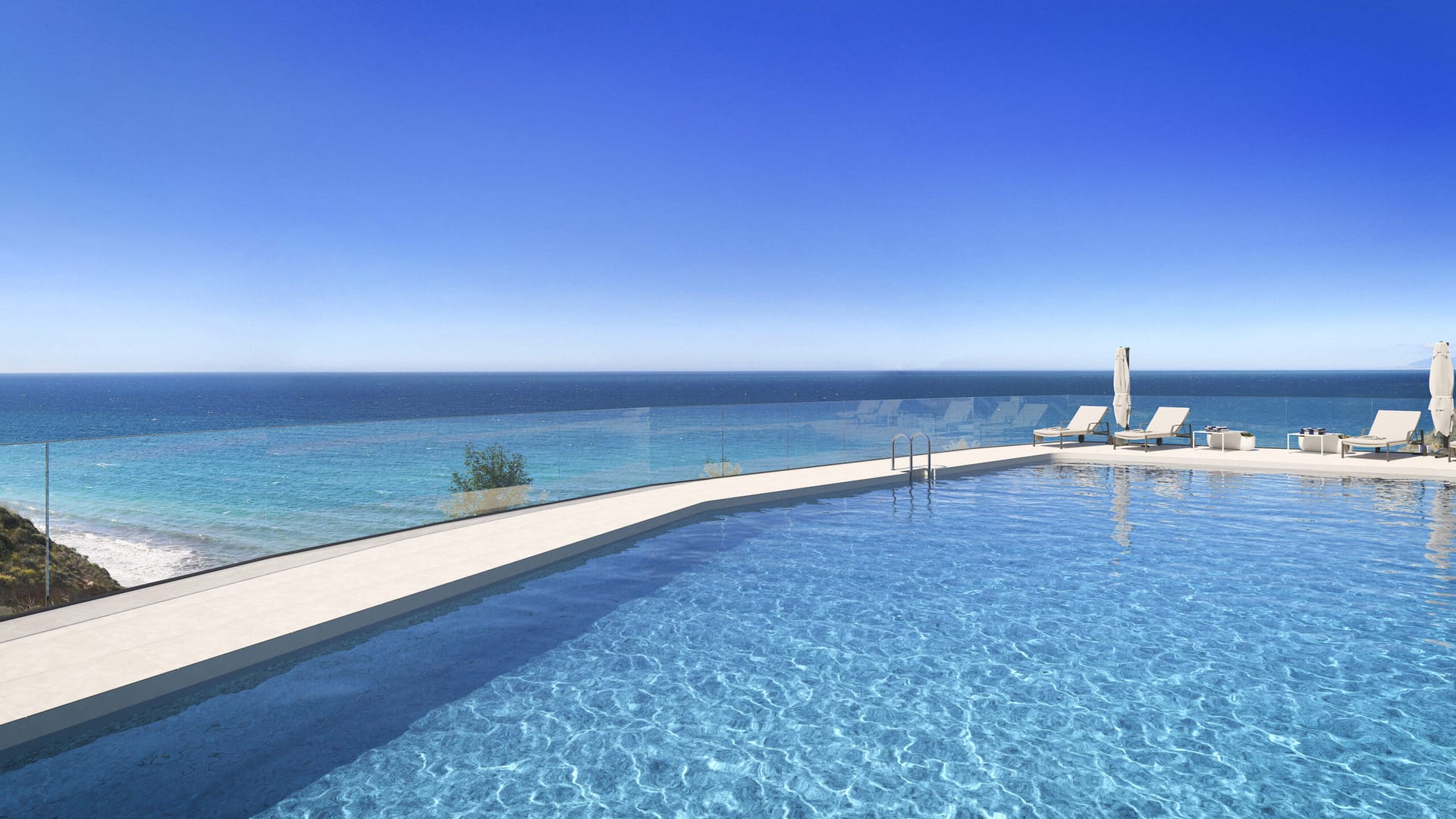 The shared pool behind a glass balustrade, with sun loungers at its far end and the sea below. Proa, Lagos, Vélez-Málaga.