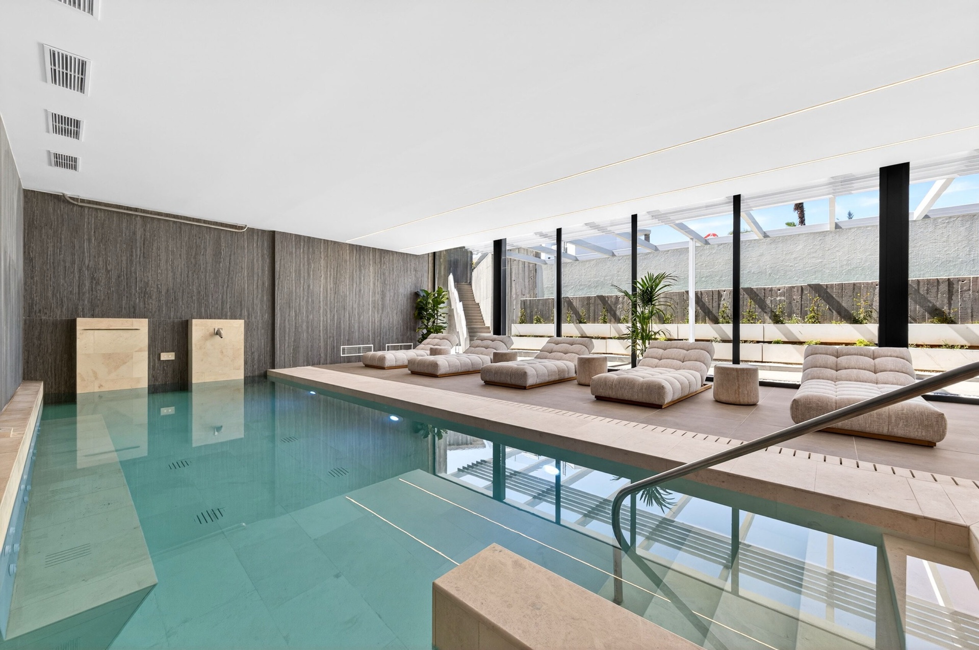 The indoor spa pool, with a row of loungers along one side and a staircase up to the garden. Quintessence, Altos de los Monteros, Marbella.