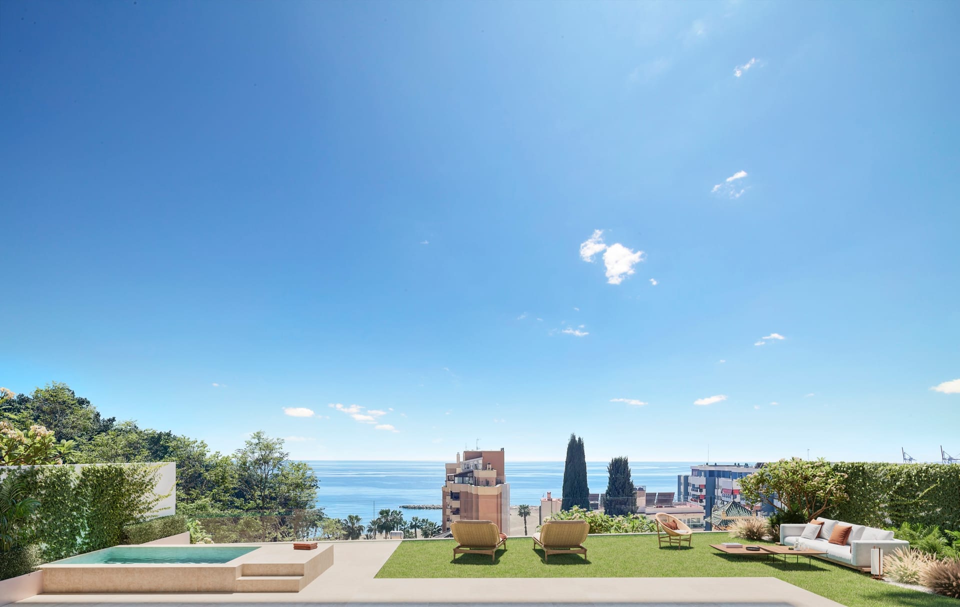 A lawn with a small plunge pool, loungers and an outdoor sofa, with the sea and the Málaga seafront beyond. Ramal de Monte Sancha, Monte Sancha, Málaga.
