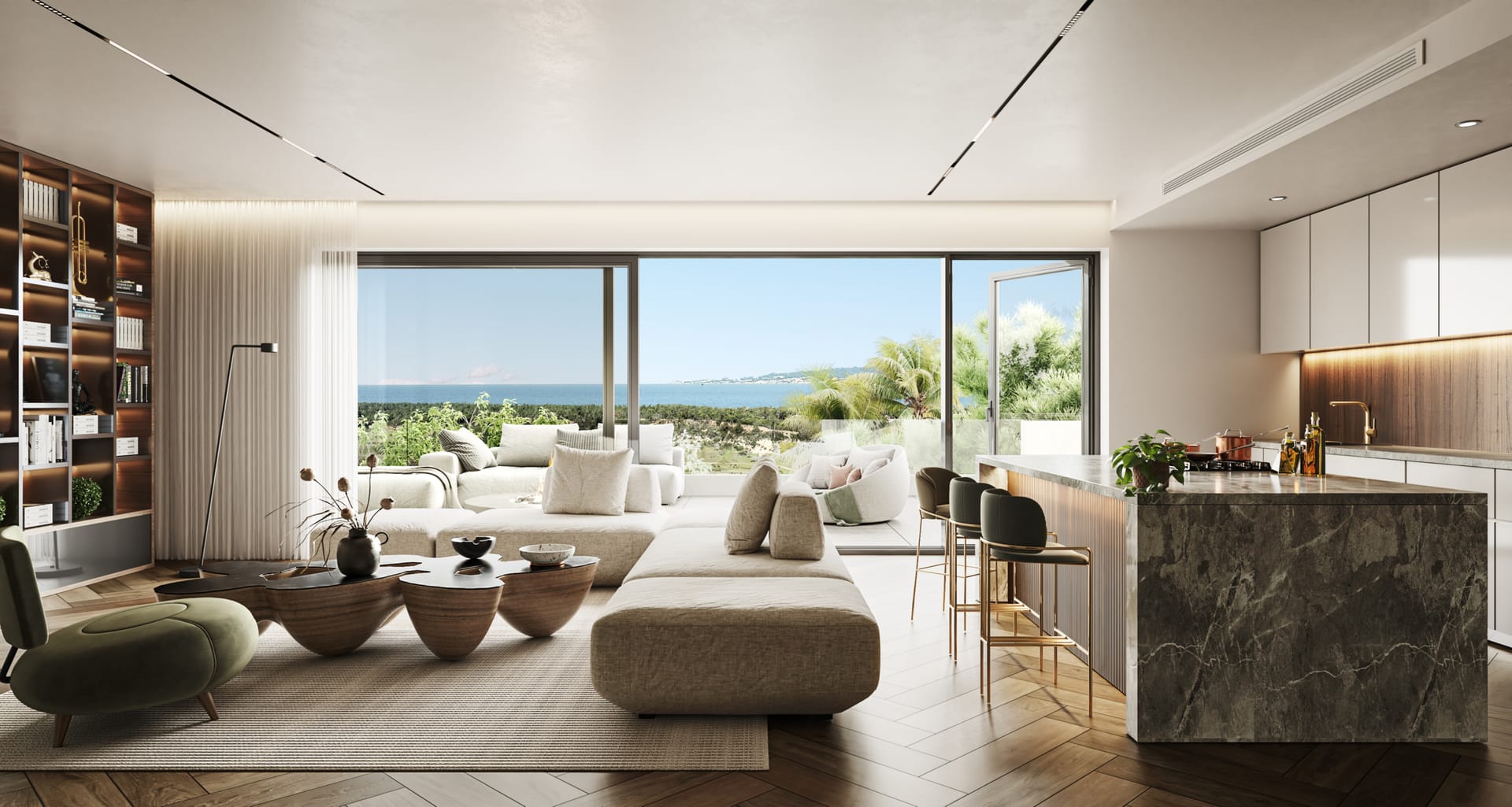The living room and kitchen of a penthouse, with a dark stone island and the sea beyond the terrace doors. Royal River, Río Real, Marbella.