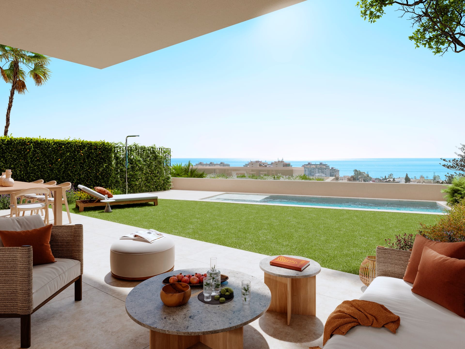 A covered terrace with outdoor sofas, a lawn and a long pool, with the sea on the horizon. San Federico, Pedregalejo, Málaga.