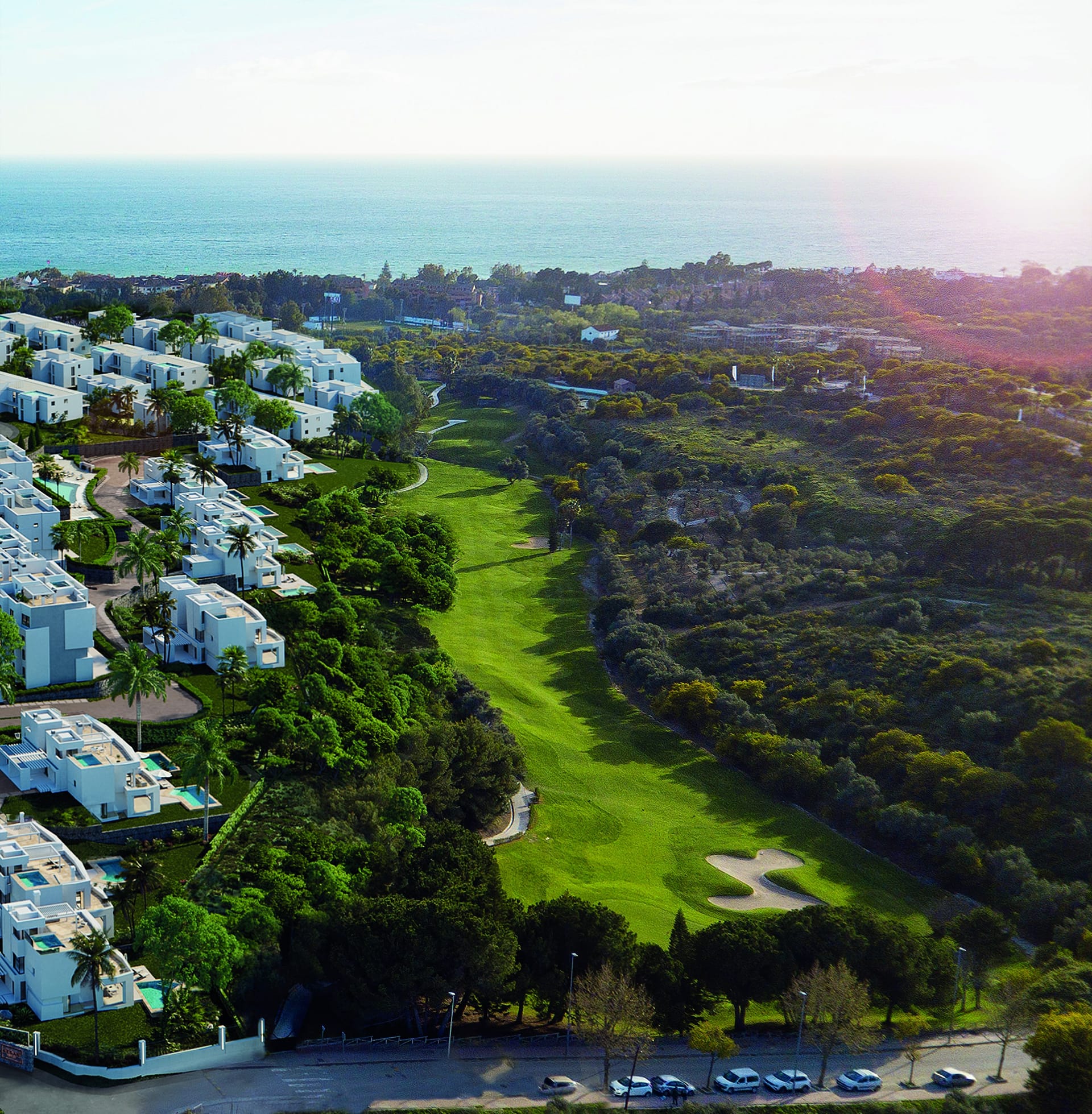 An aerial view of the white buildings of the wider scheme beside a golf fairway, with the sea beyond. Soul Marbella Sunlife III, Los Monteros, Marbella.