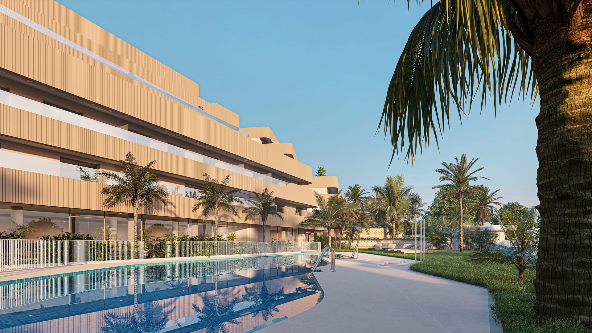 The outdoor pool running along the foot of the buildings, lined with palm trees. South Sand, Las Mesas, Estepona.