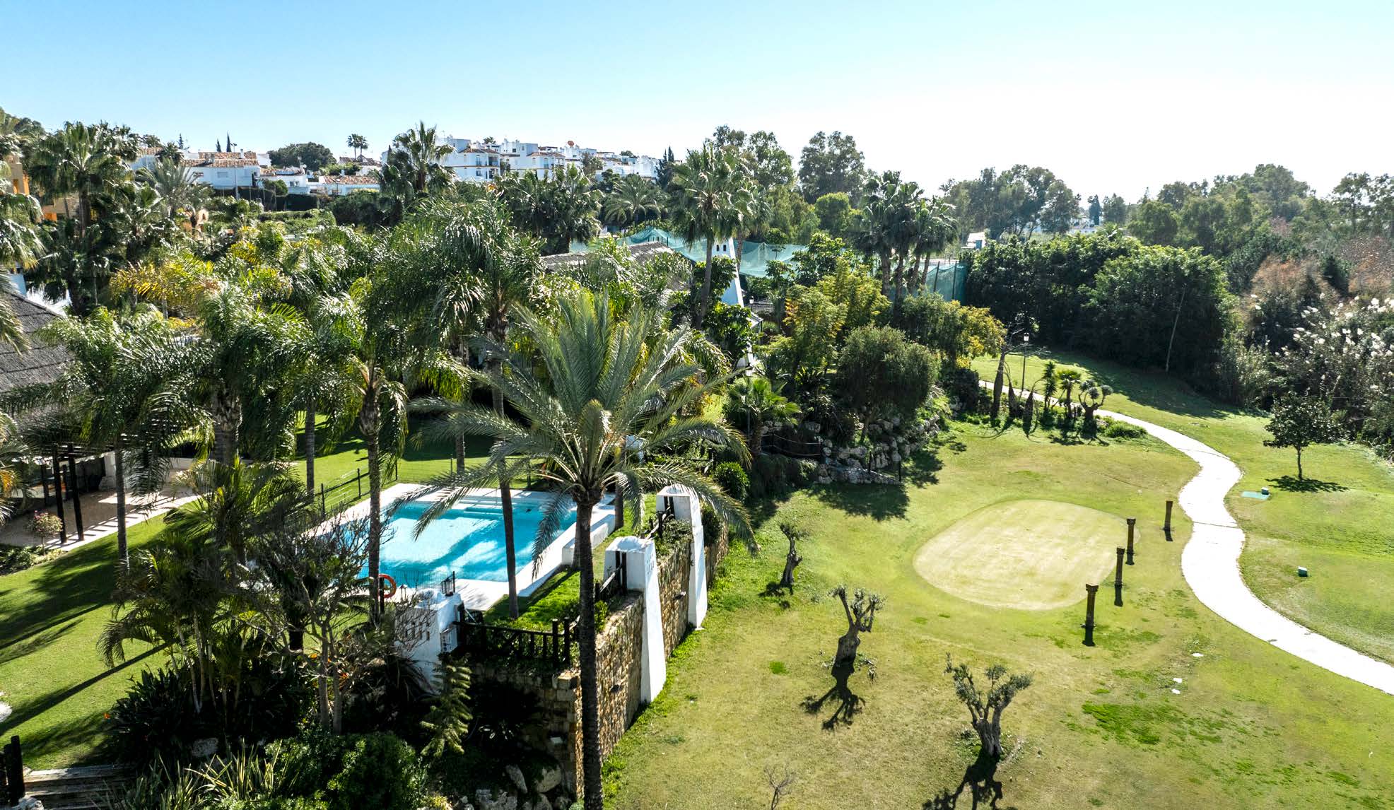 The club’s outdoor pool and gardens, beside a green on the golf course. The Club Villas, El Campanario, Estepona.