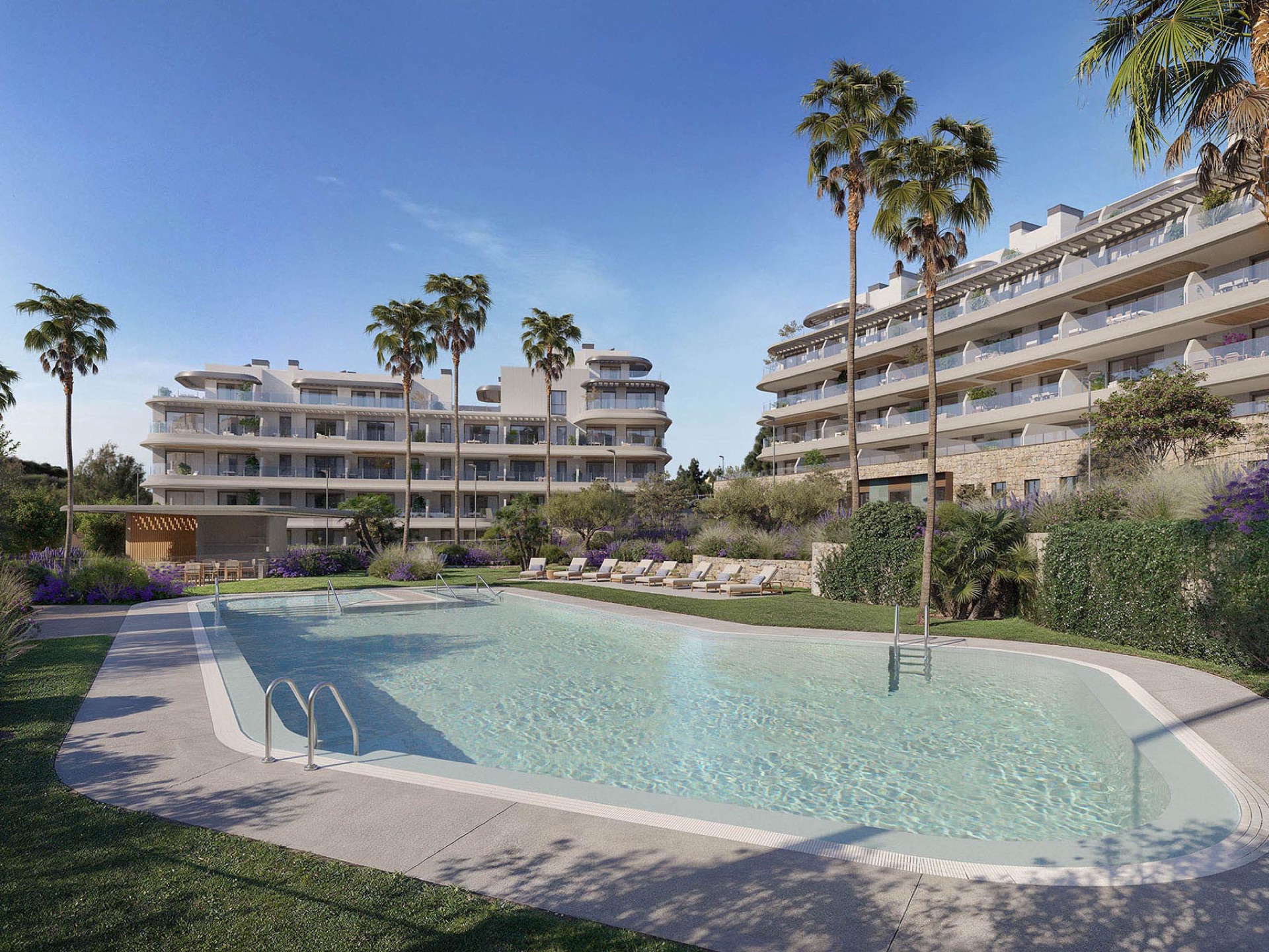 One of the outdoor pools, set in a lawn with palm trees and the buildings behind. The Kove, Hipódromo, Mijas.