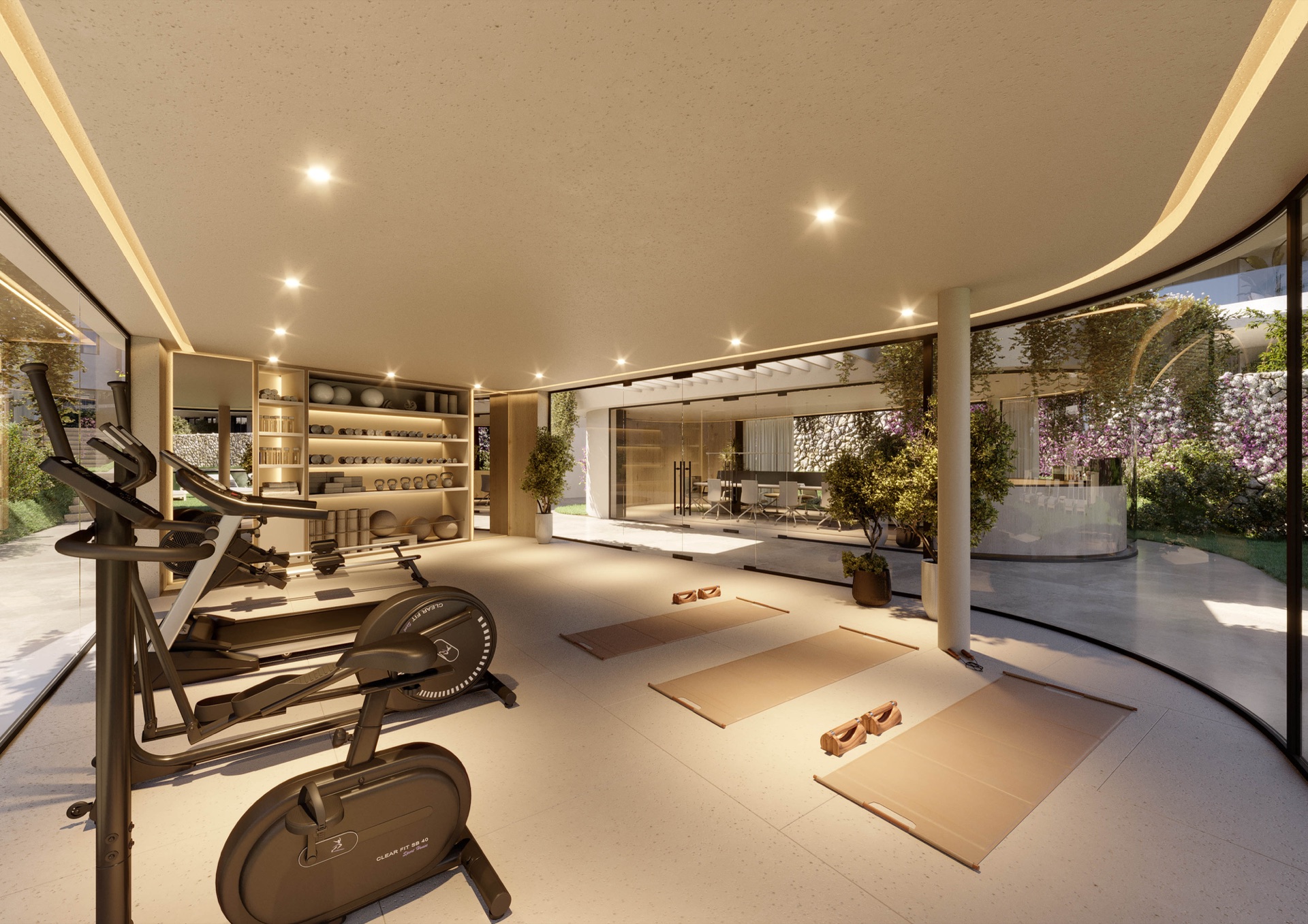 The gym, with an exercise bike and mats beside a curved glass wall onto the gardens. The Palms at Estepona, Avenida Bernardo de Gálvez, Estepona.