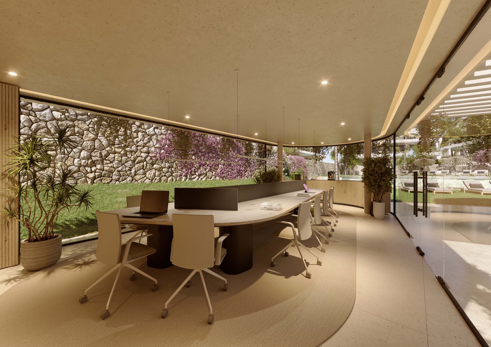 The shared room for working, with desks and office chairs in front of a stone wall and a glass front onto the gardens. The Palms at Estepona, Avenida Bernardo de Gálvez, Estepona.
