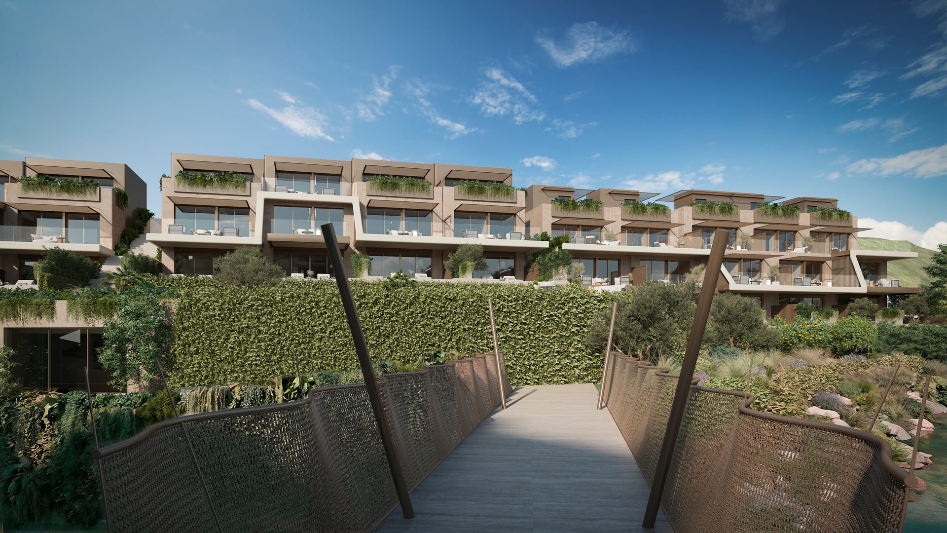 The footbridge across the stream, with woven metal sides, leading to the townhouses on the far side of the valley. The Valley, Elviria, Marbella.