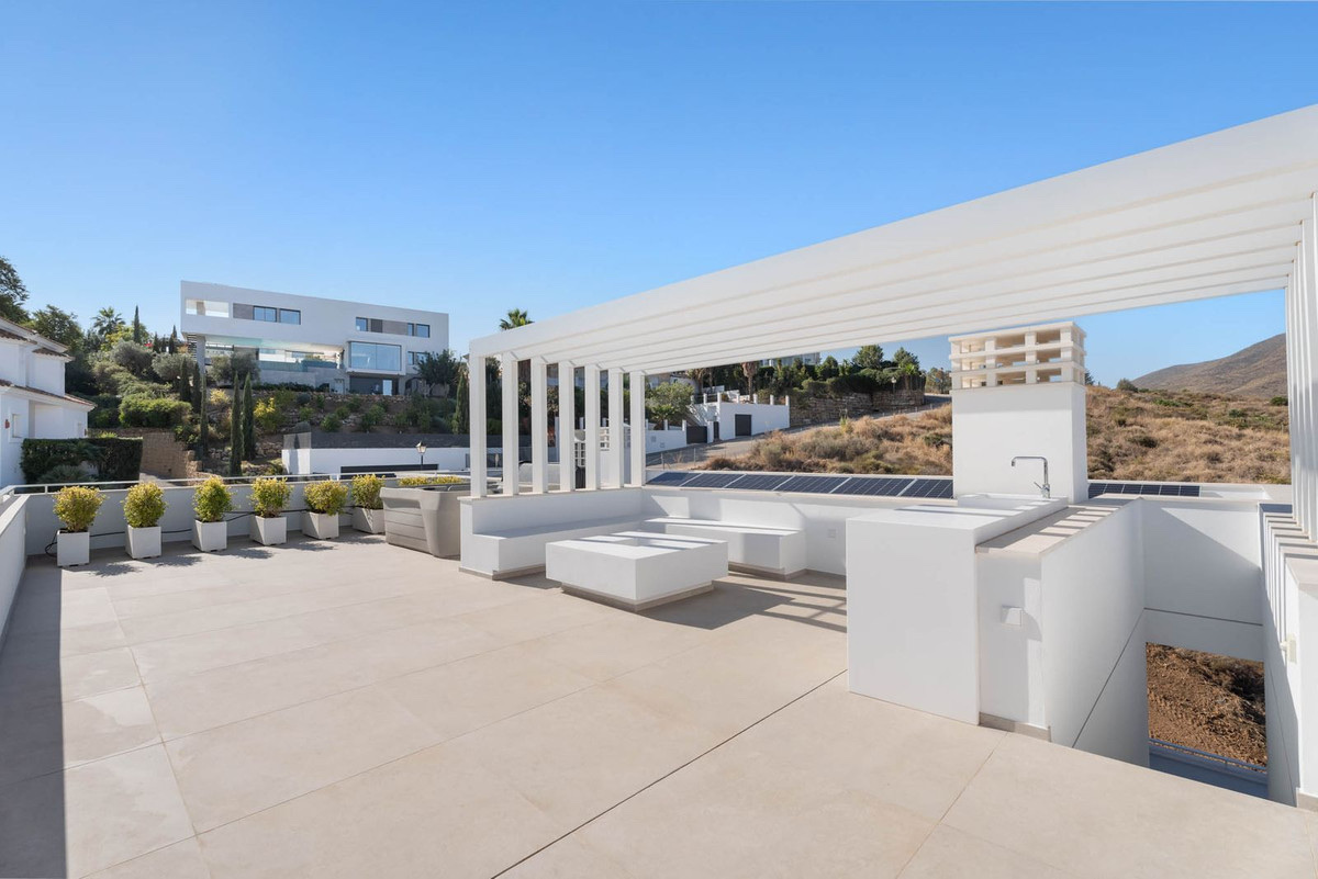 The roof terrace of the finished villa, with a white pergola over built-in seating. Tree Villas, La Cala Golf, Mijas.