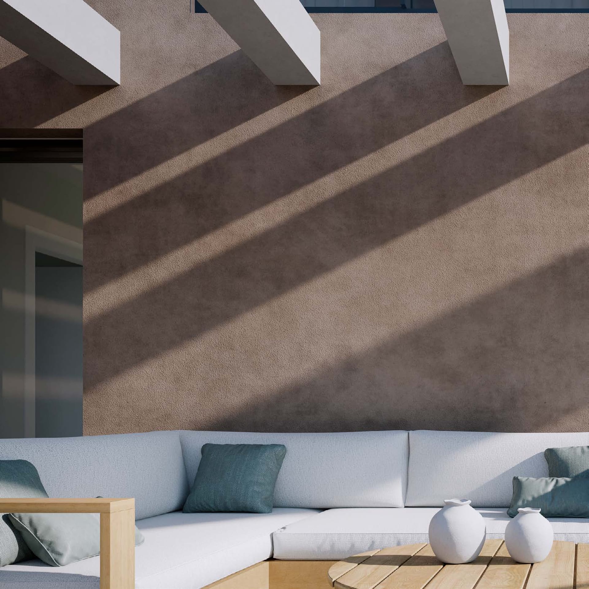 An outdoor sofa on a terrace, with the shadows of the pergola falling across the wall behind it. Unika I, Buenas Noches, Estepona.