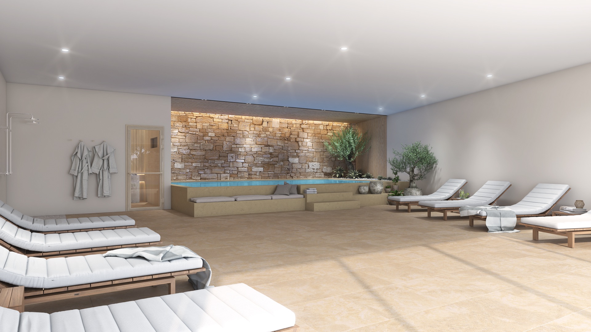 The spa, where the heated indoor pool runs along a stone wall lit from above, with loungers across the floor in front of it. Urban City Horizon, Torreblanca, Fuengirola.