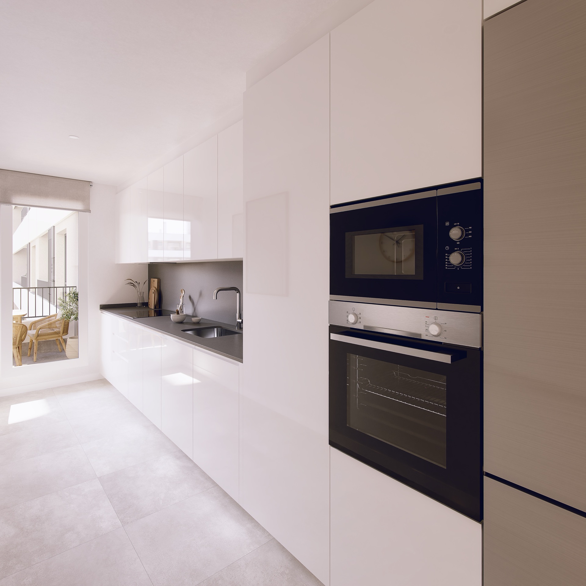 The kitchen, with white units, a dark worktop and the oven and microwave built into a tall column. Urban Zenit, Distrito Zeta, Málaga.