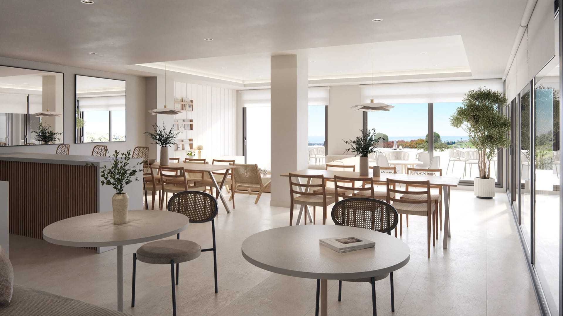 The community room, with café tables and a long dining table beside glass doors to a terrace. Vanian Park, La Resina, Estepona.