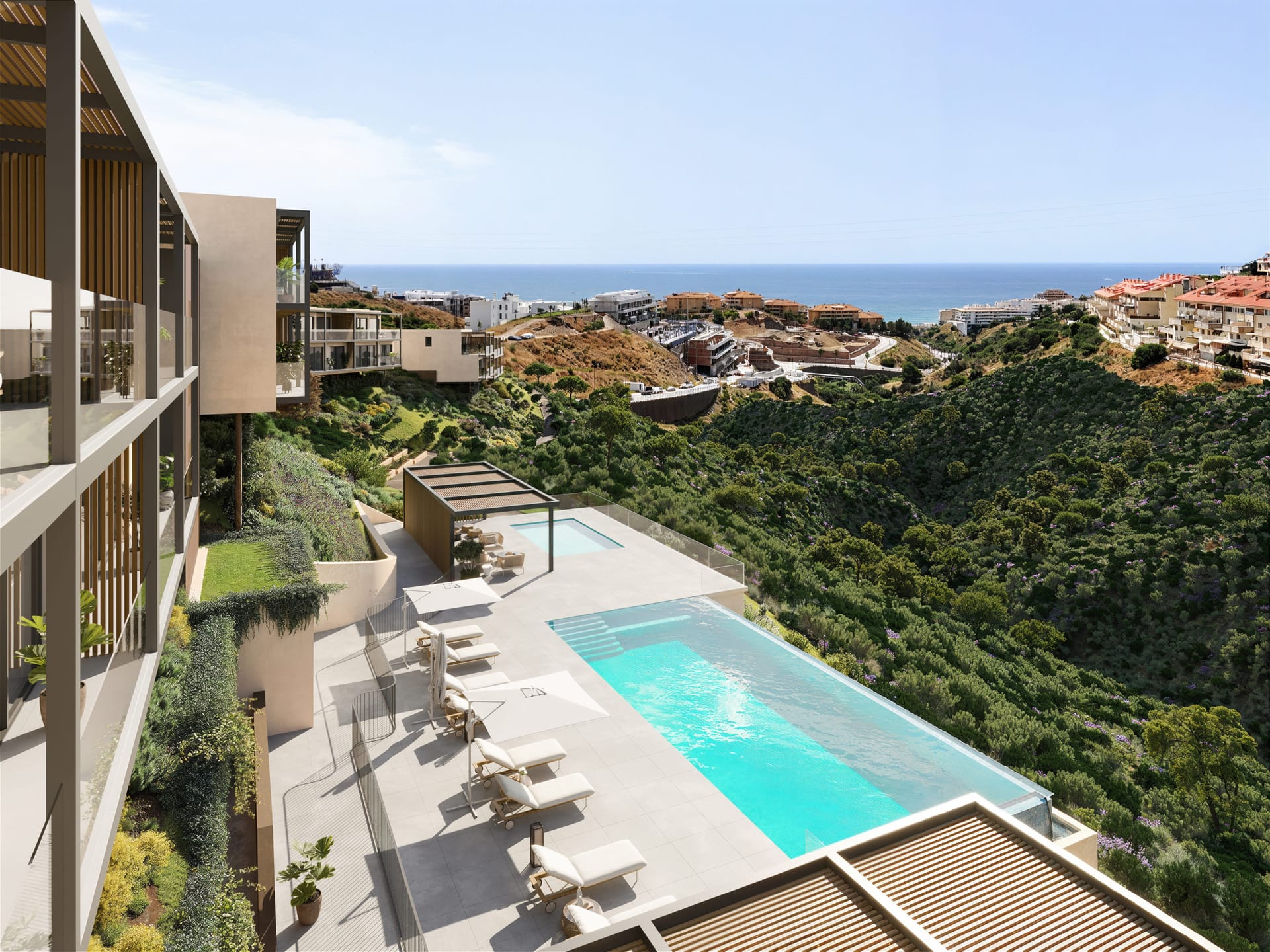 The infinity pool seen from above, with a smaller pool and a pergola beyond it and a tree-covered slope alongside. Veridian, El Higuerón, Fuengirola.