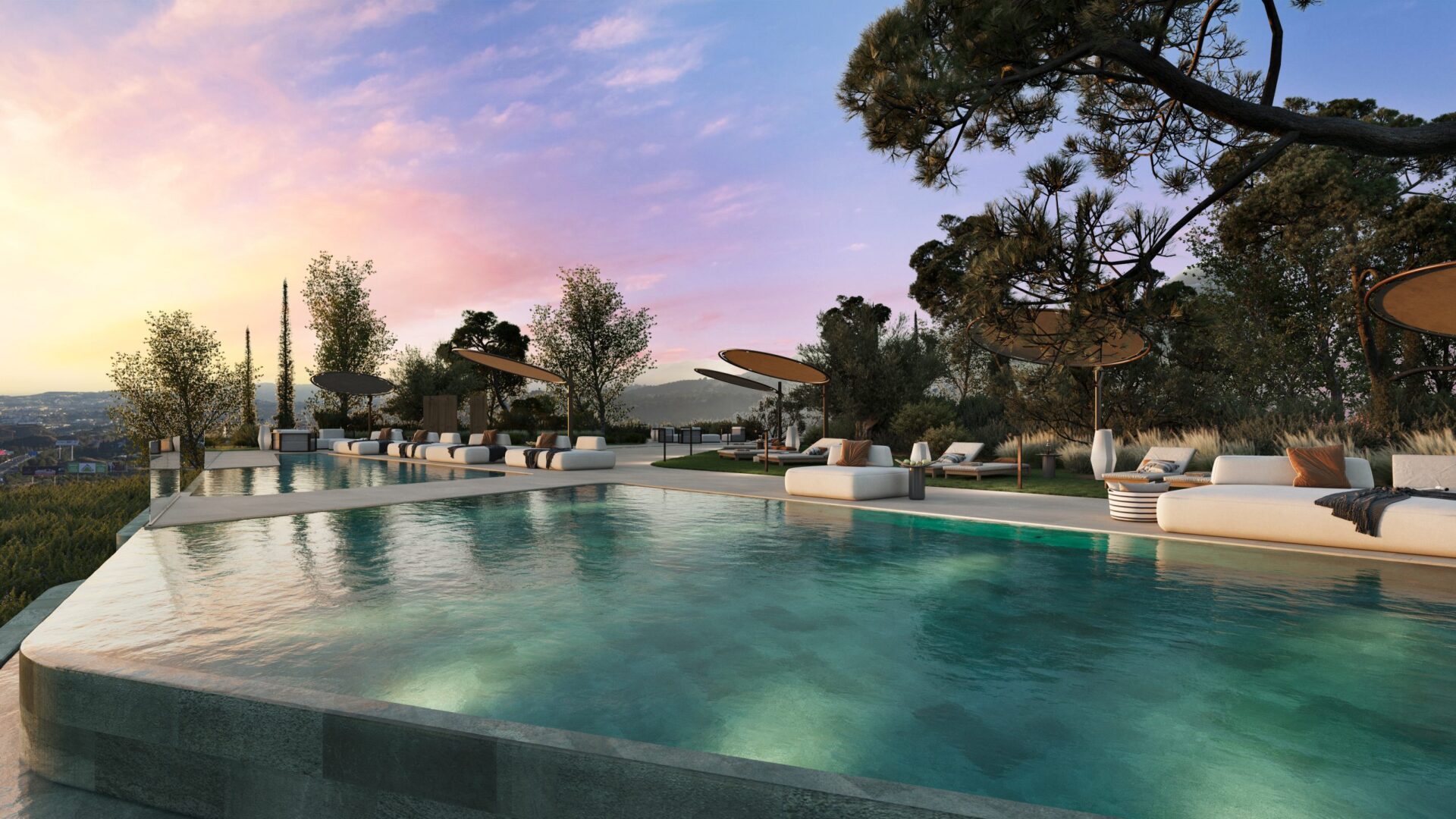 A pool at dusk, with loungers beneath the trees beside it. Waterfall Residences, El Higuerón, Fuengirola.